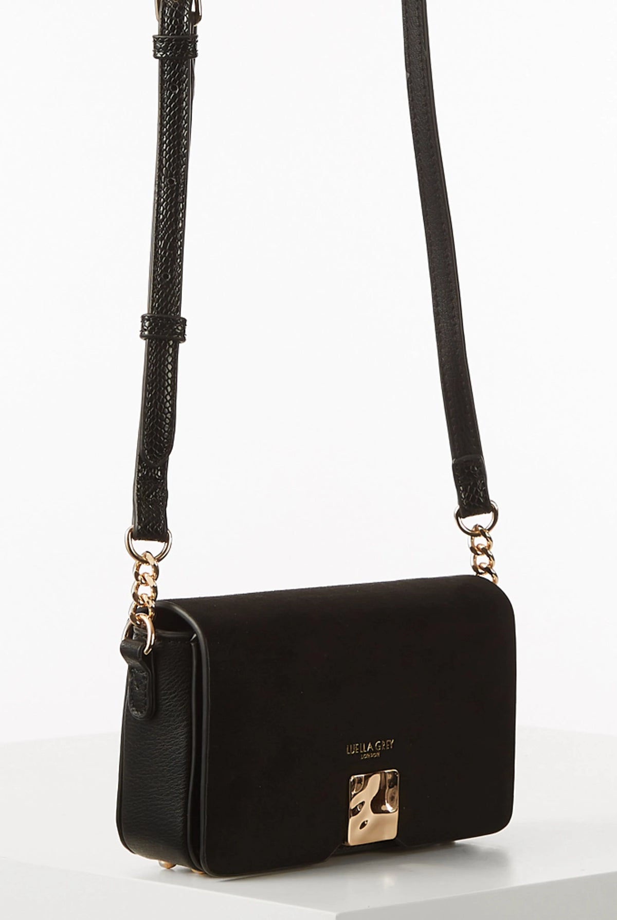 Black flap shoulder bag with gold-tone clasp, front logo, and braided shoulder strap