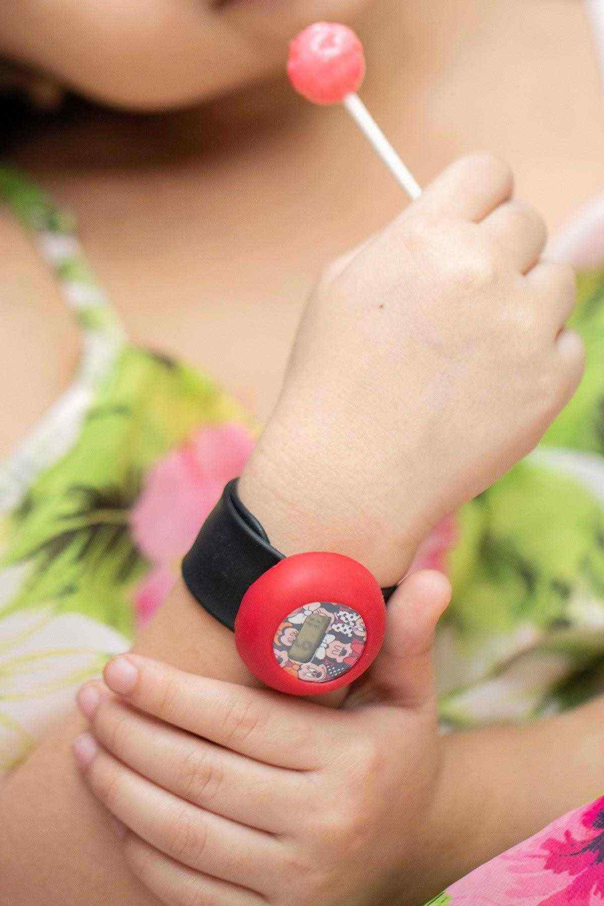 Disney cartoon digital watch on wrist with black strap and red bezel, close view