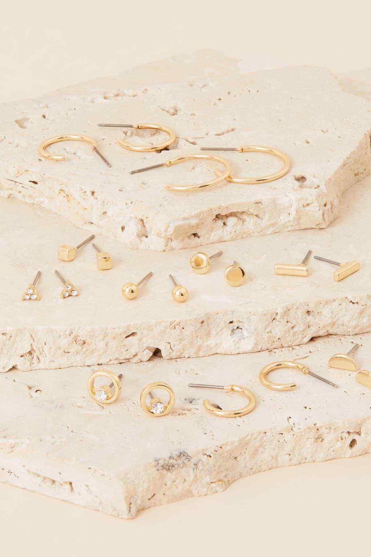 Assorted gold hoop and stud earrings, flat lay assortment