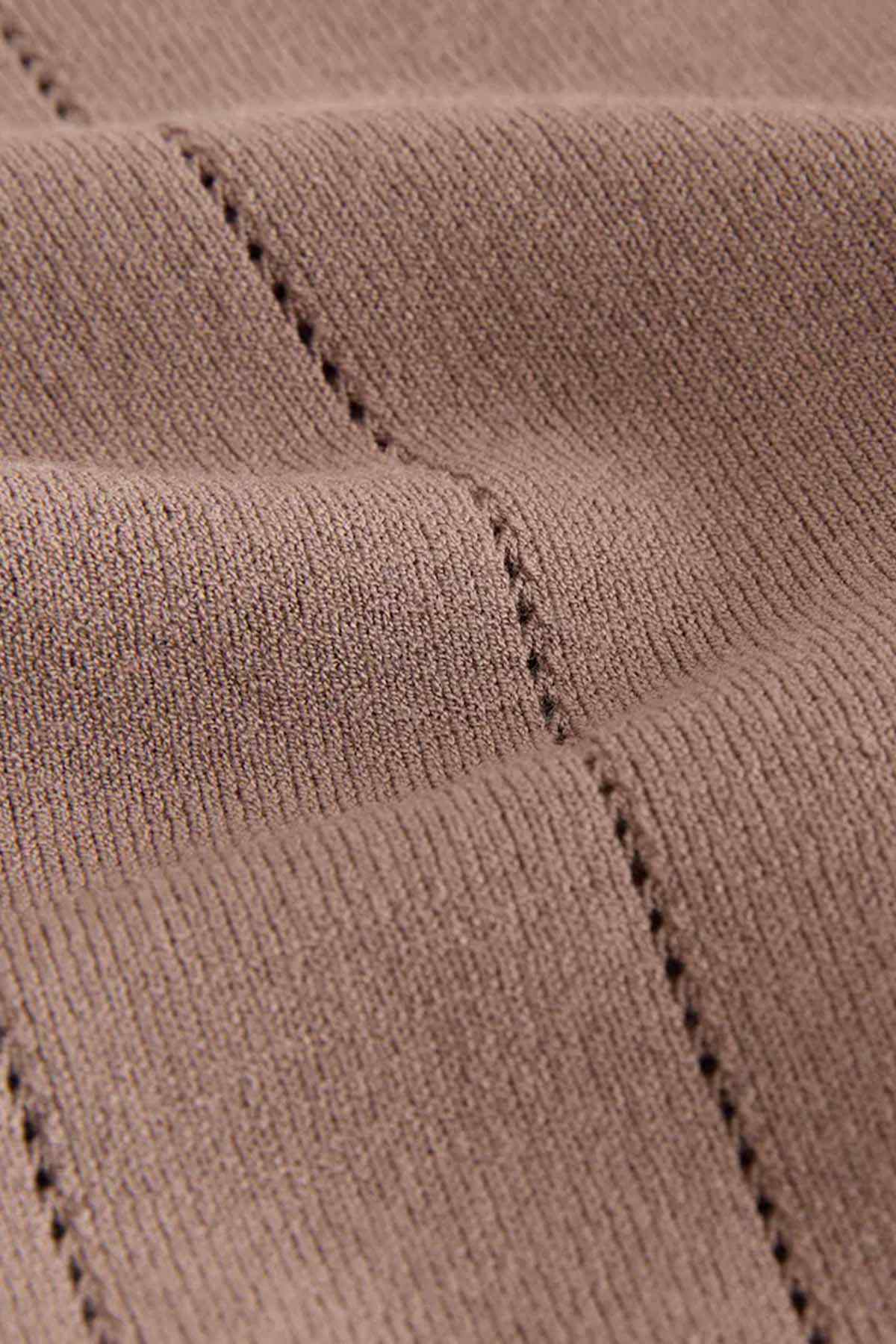 Taupe polo shirt fabric close-up showing curved seam stitching
