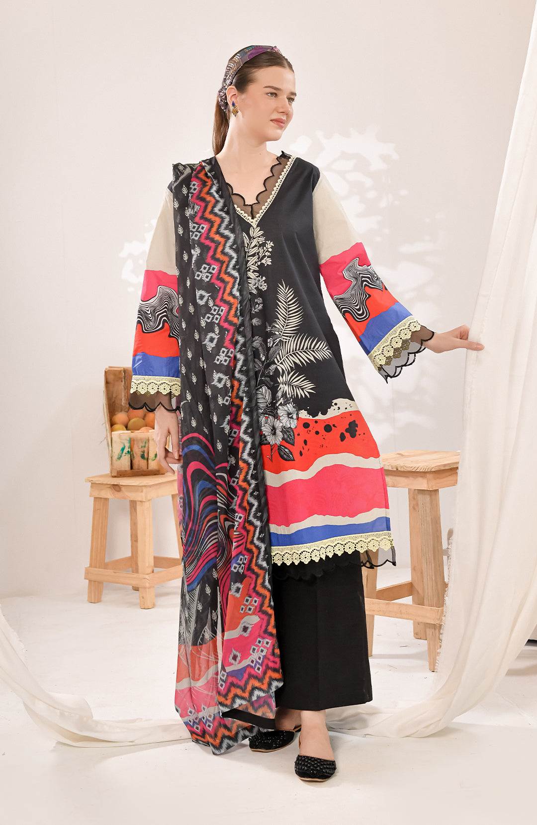 Long patterned maxi dress in black with red and blue print and scalloped lace trim