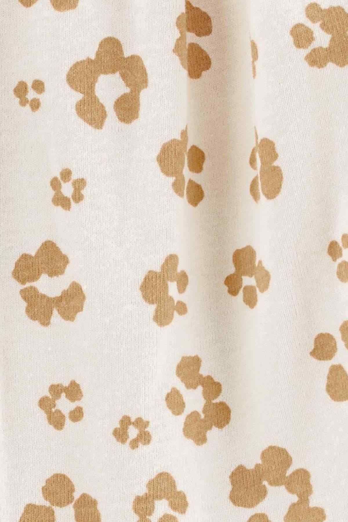Cream fabric closeup with tan paw-print pattern