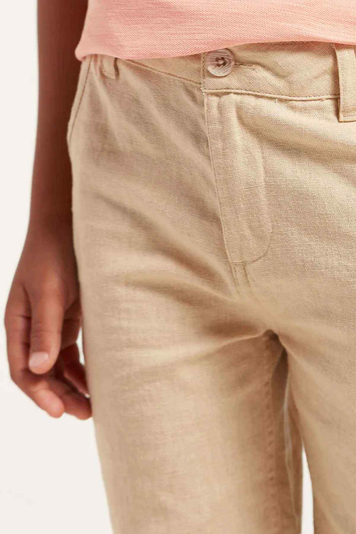Beige shorts close-up with button waistband and front pockets