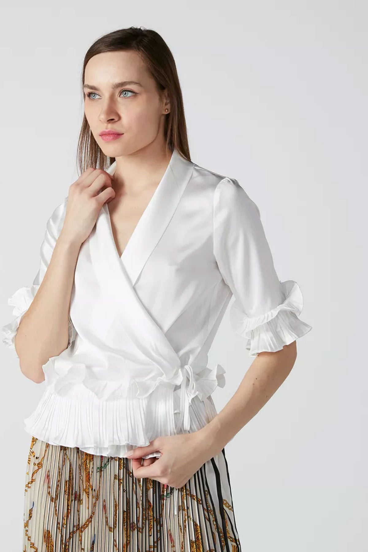 White wrap blouse with puff sleeves and ruffled hem