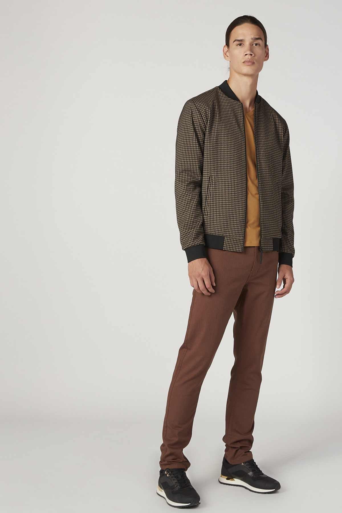 Beige houndstooth bomber jacket worn with matching brown trousers