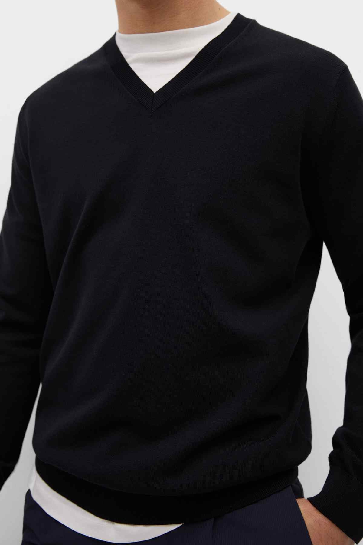 Black V-neck sweater detail with V collar and ribbed waistband