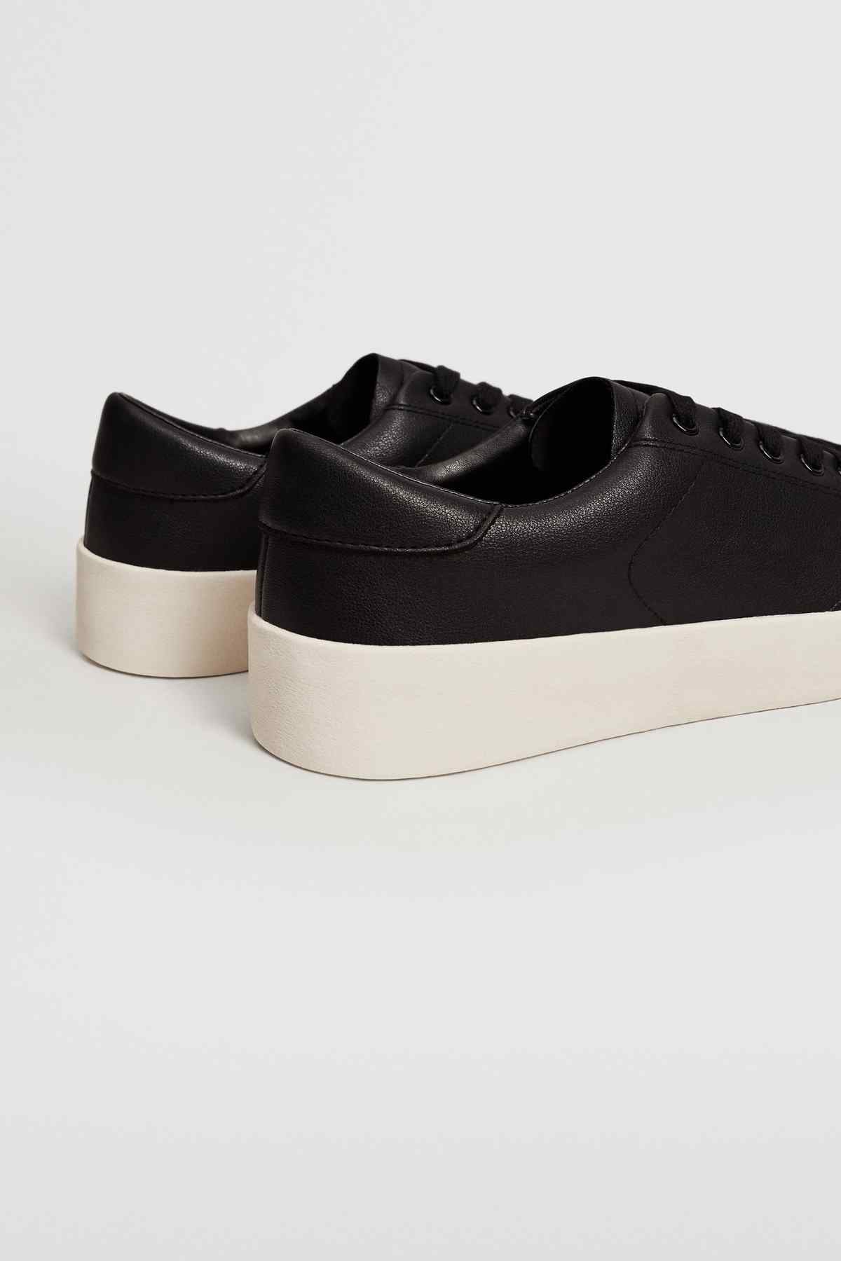 Black leather-look sneakers with thick white platform sole and lace-up upper