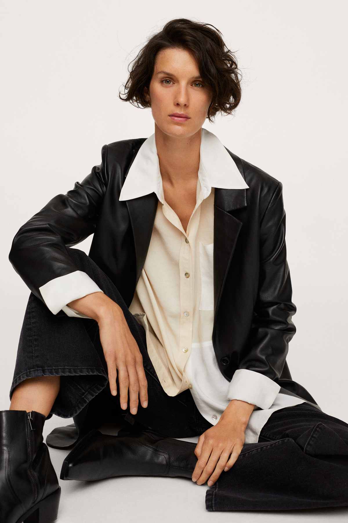 Off-white button-up shirt with pointed collar and long sleeves, worn under a jacket