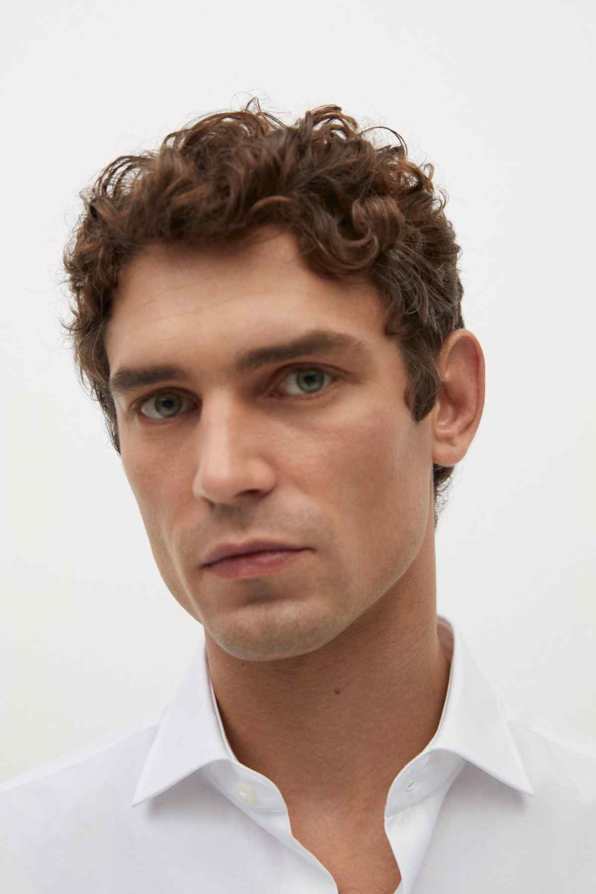 White dress shirt neckline close-up with spread collar and top button fastening.
