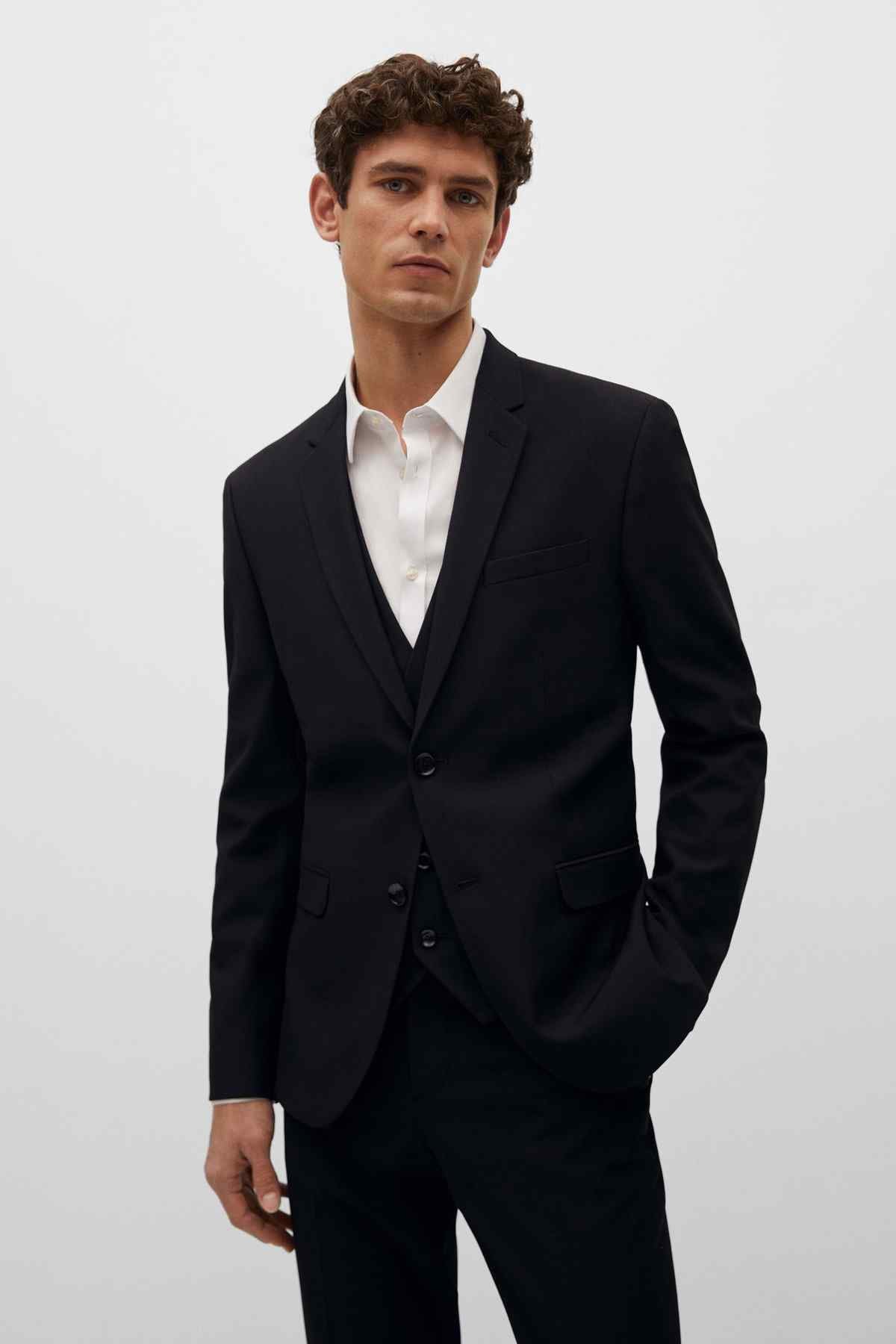 Men's black suit with white dress shirt and waistcoat detail