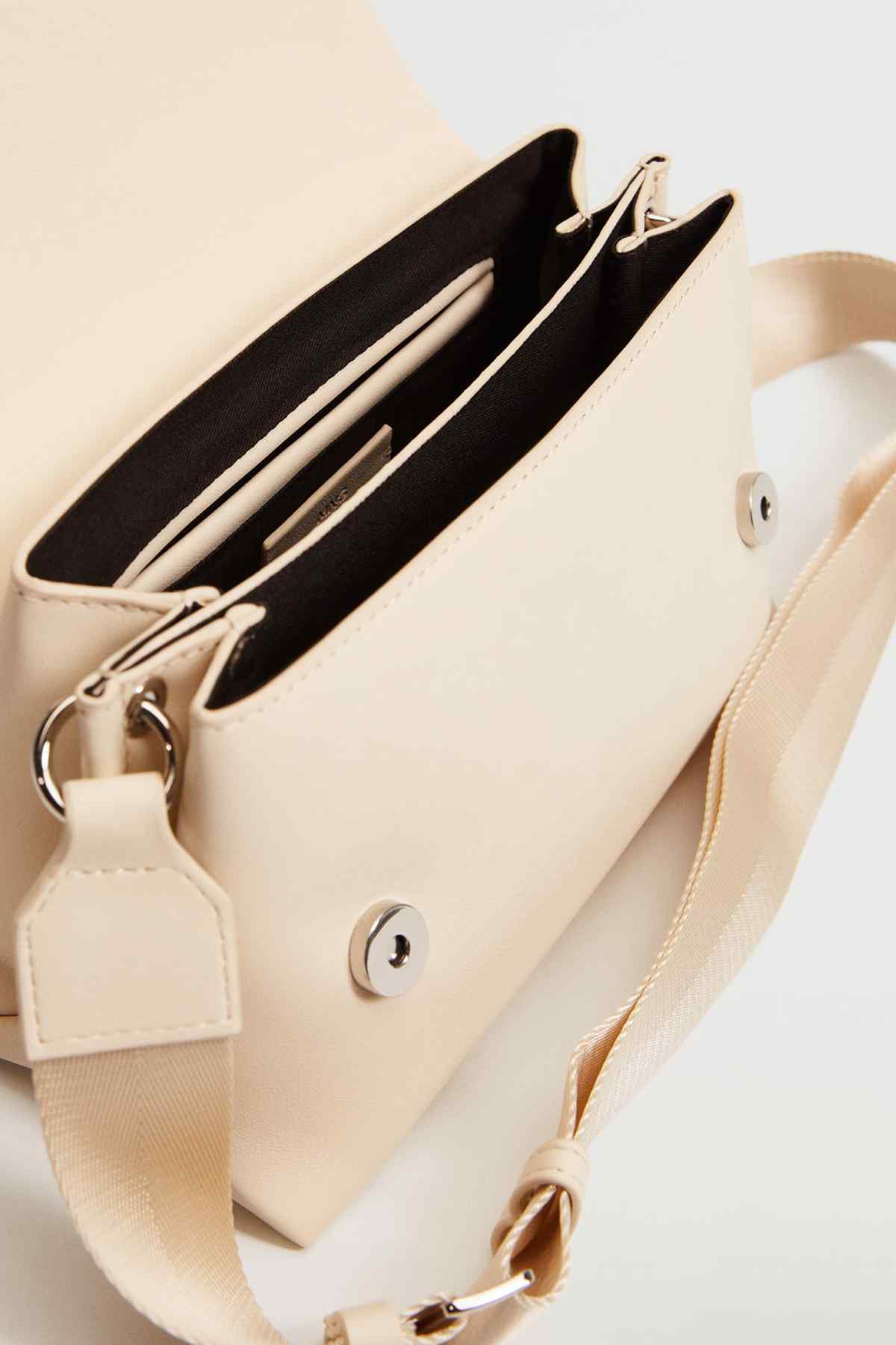 Off-white shoulder bag open view showing black lining, inner pockets, and metal button