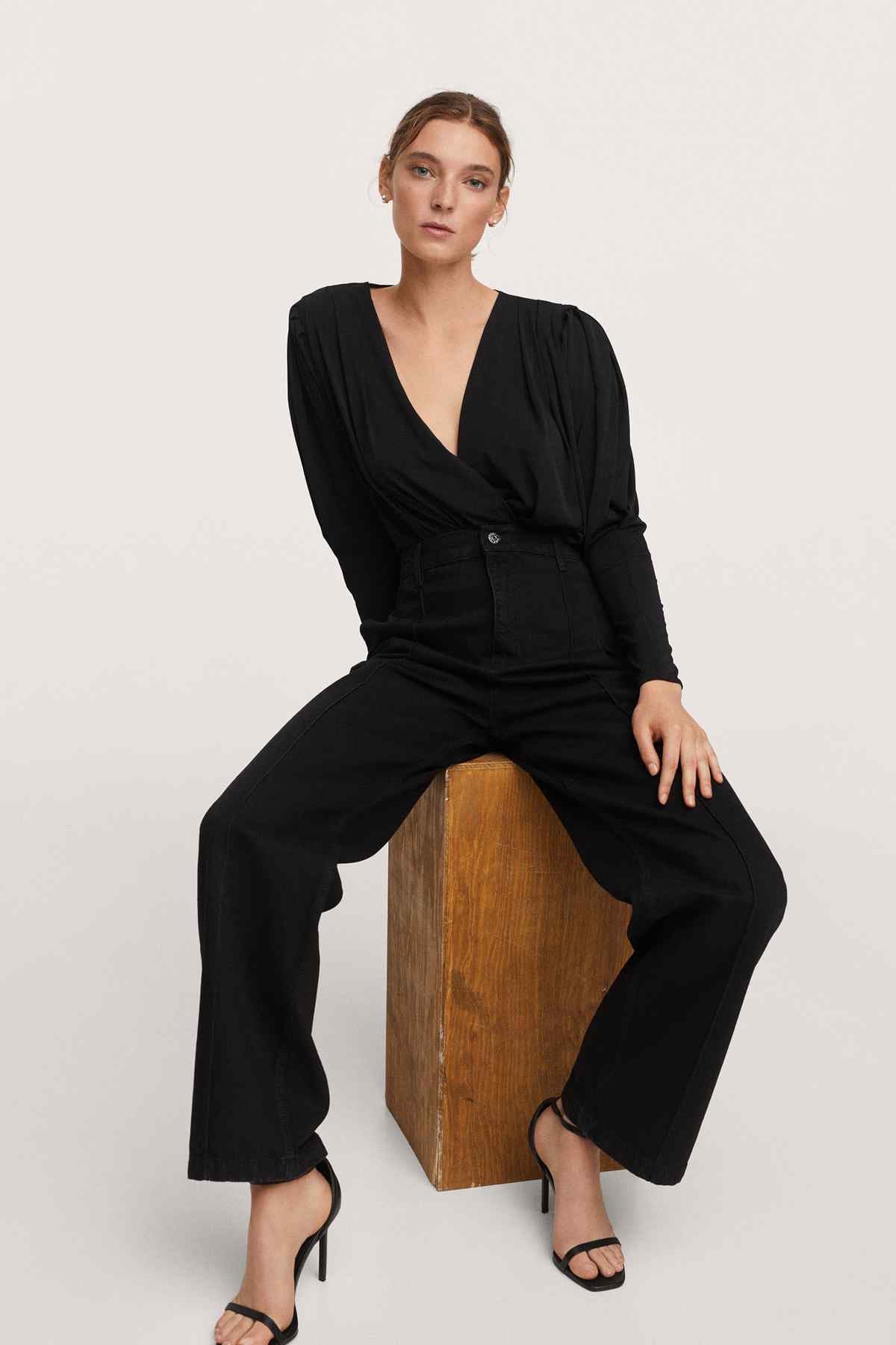 Black denim V-neck jumpsuit with button front, long sleeves, wide legs