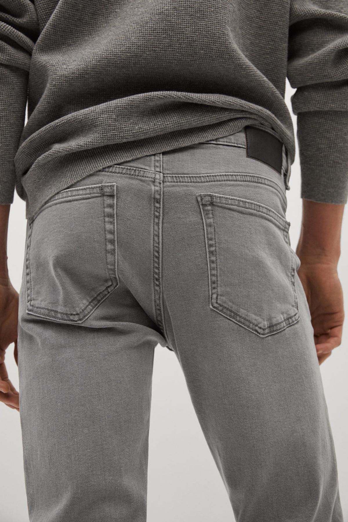 Gray denim jeans close-up of back pockets and belt loops