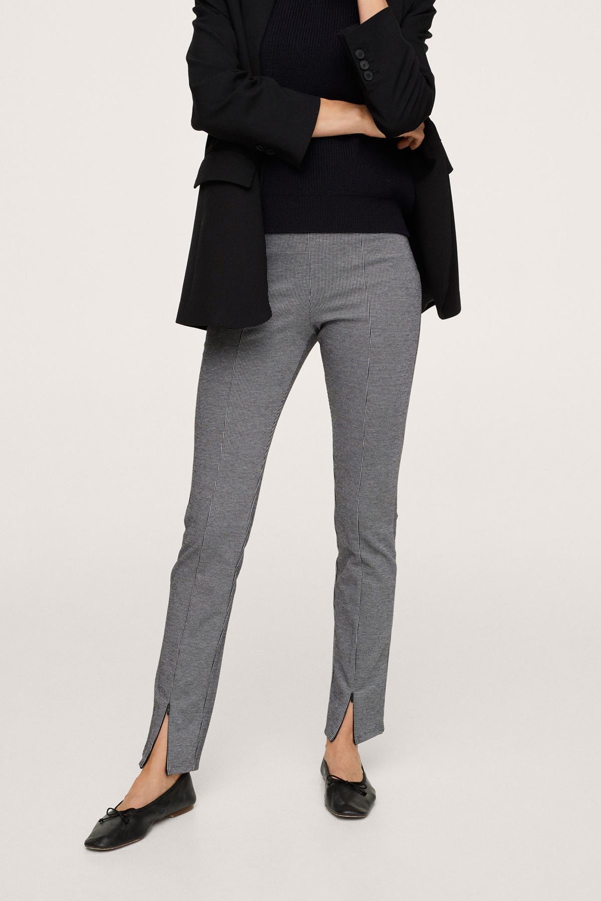 Black blazer and grey slim trousers, side view with waist detail and ankle slit