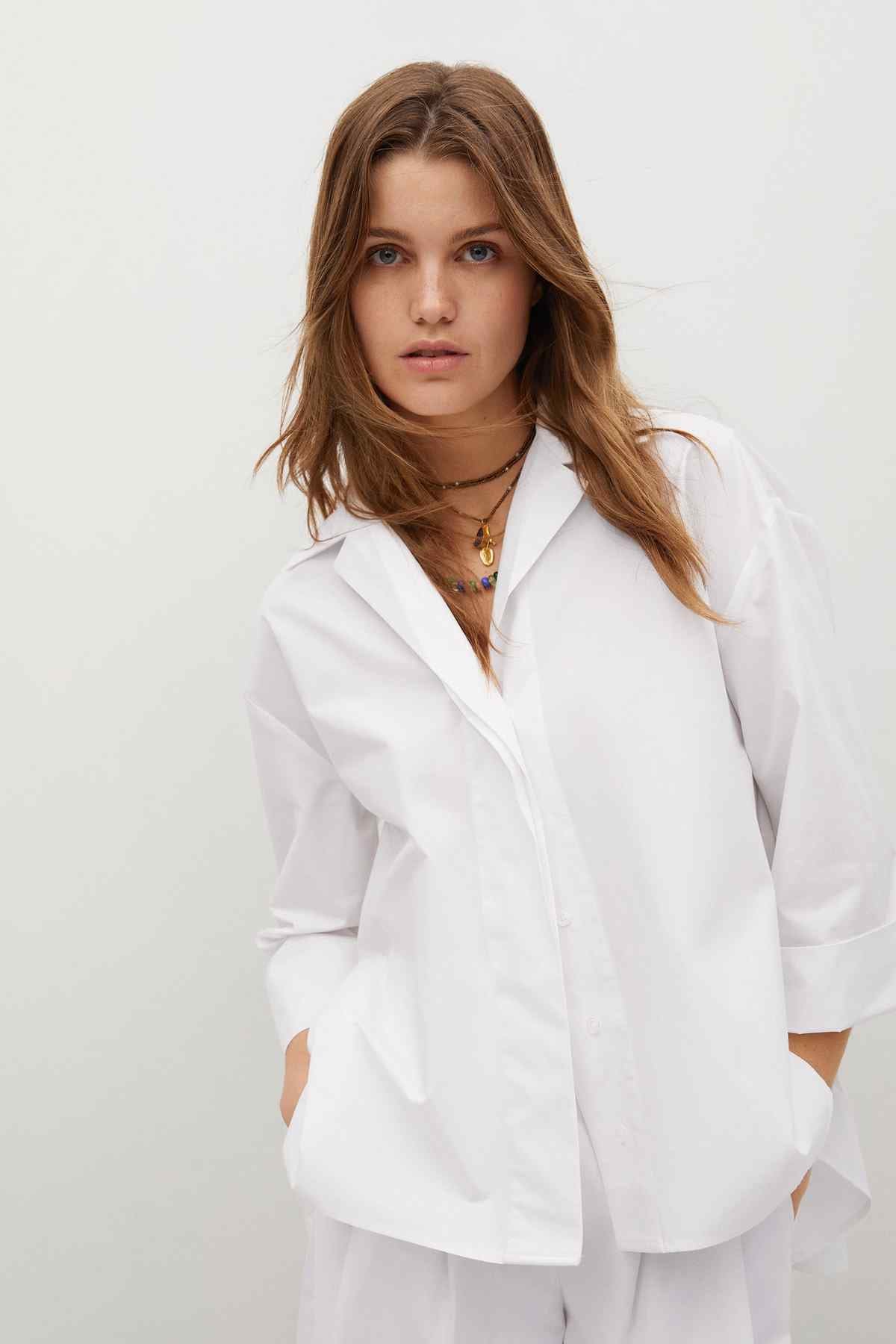 Off-white button-up blouse with open collar, long sleeves, button placket