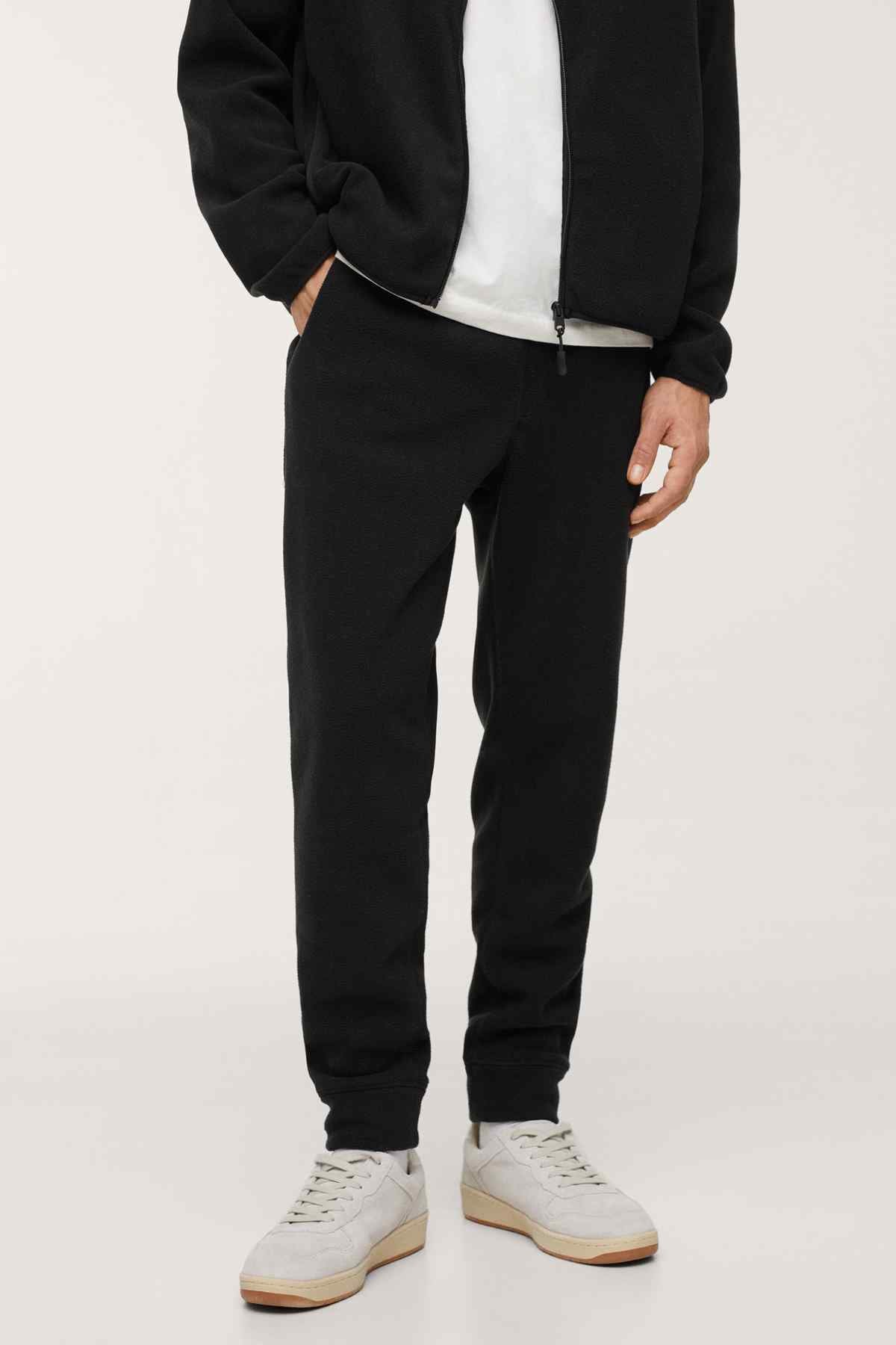 Men's black jogger pants with elastic cuffs and jacket hem zip detail