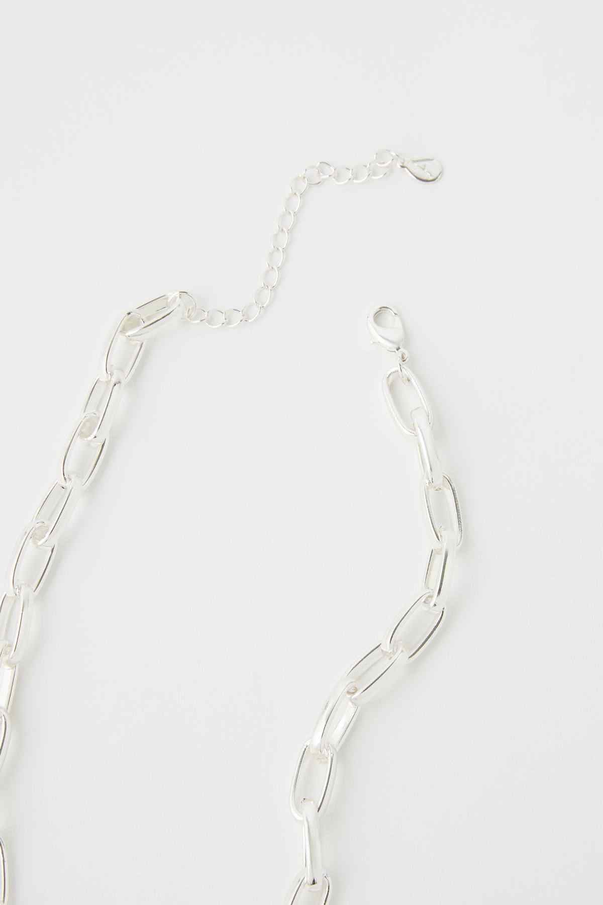 Silver chain link necklace detail with oval links and clasp hardware