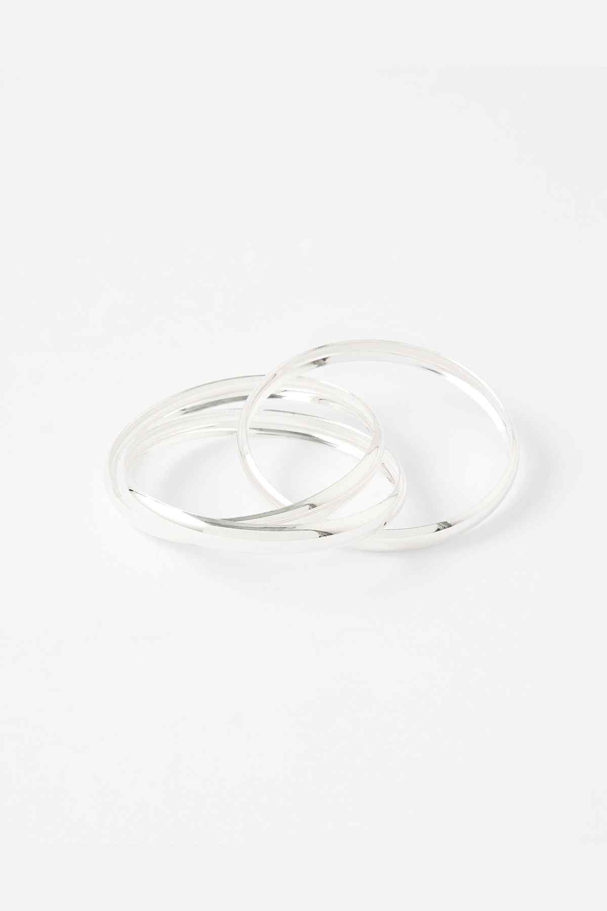 Set of silver bangles, polished metal hoops, stacked together