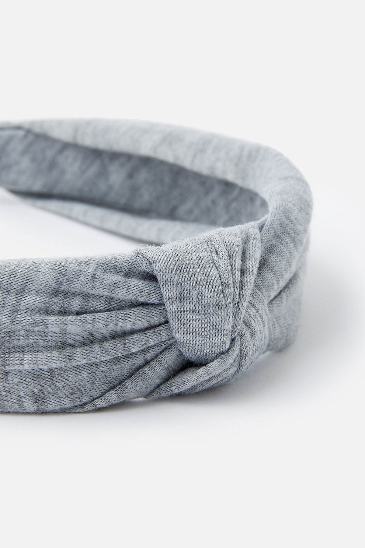 Grey fabric headband knot with stitched seam close-up