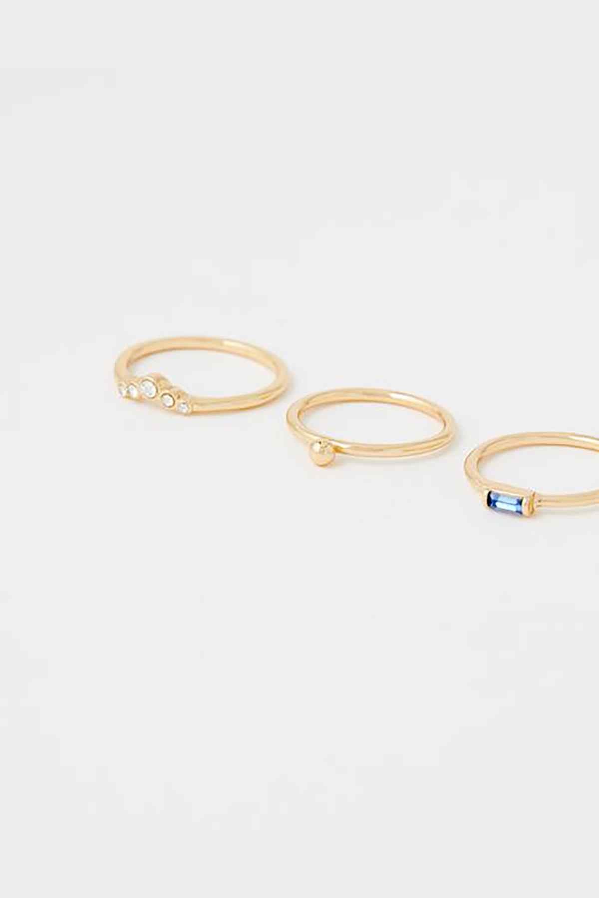Gold-tone hoop earrings, close-up of blue and clear stone detailing on hoops.