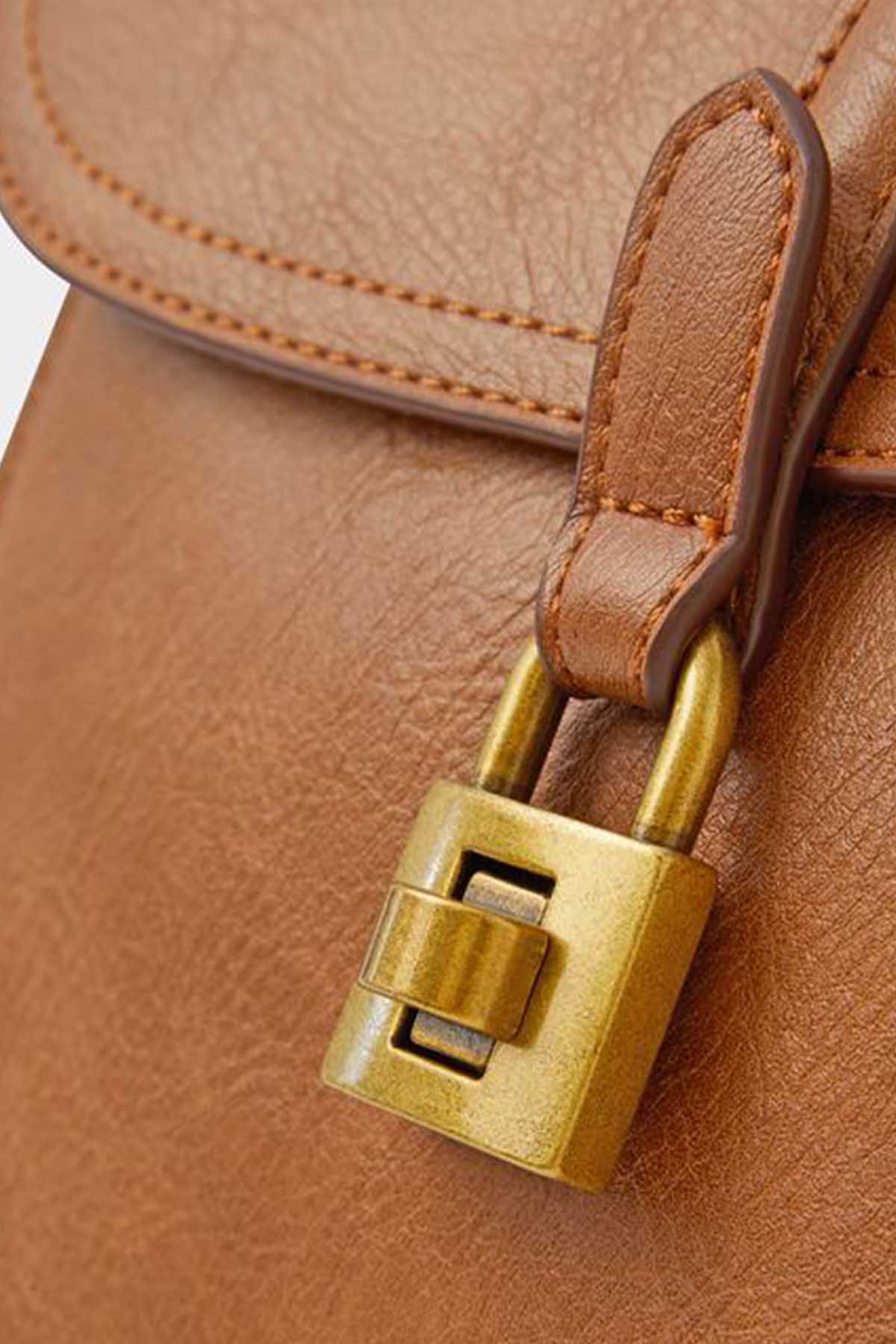 Gold-tone padlock clasp on tan leather bag with stitched strap detail