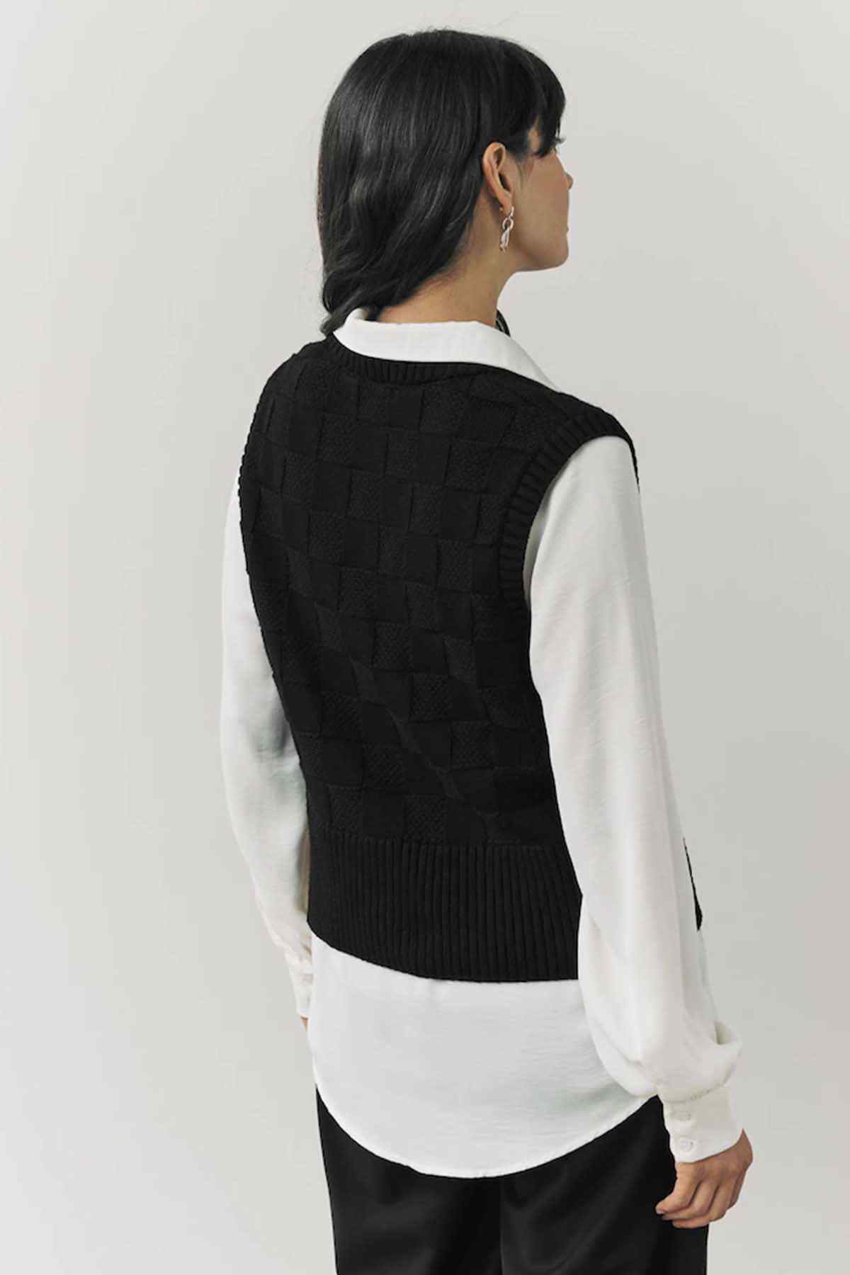 Black knit sleeveless vest back view with textured pattern and ribbed hem