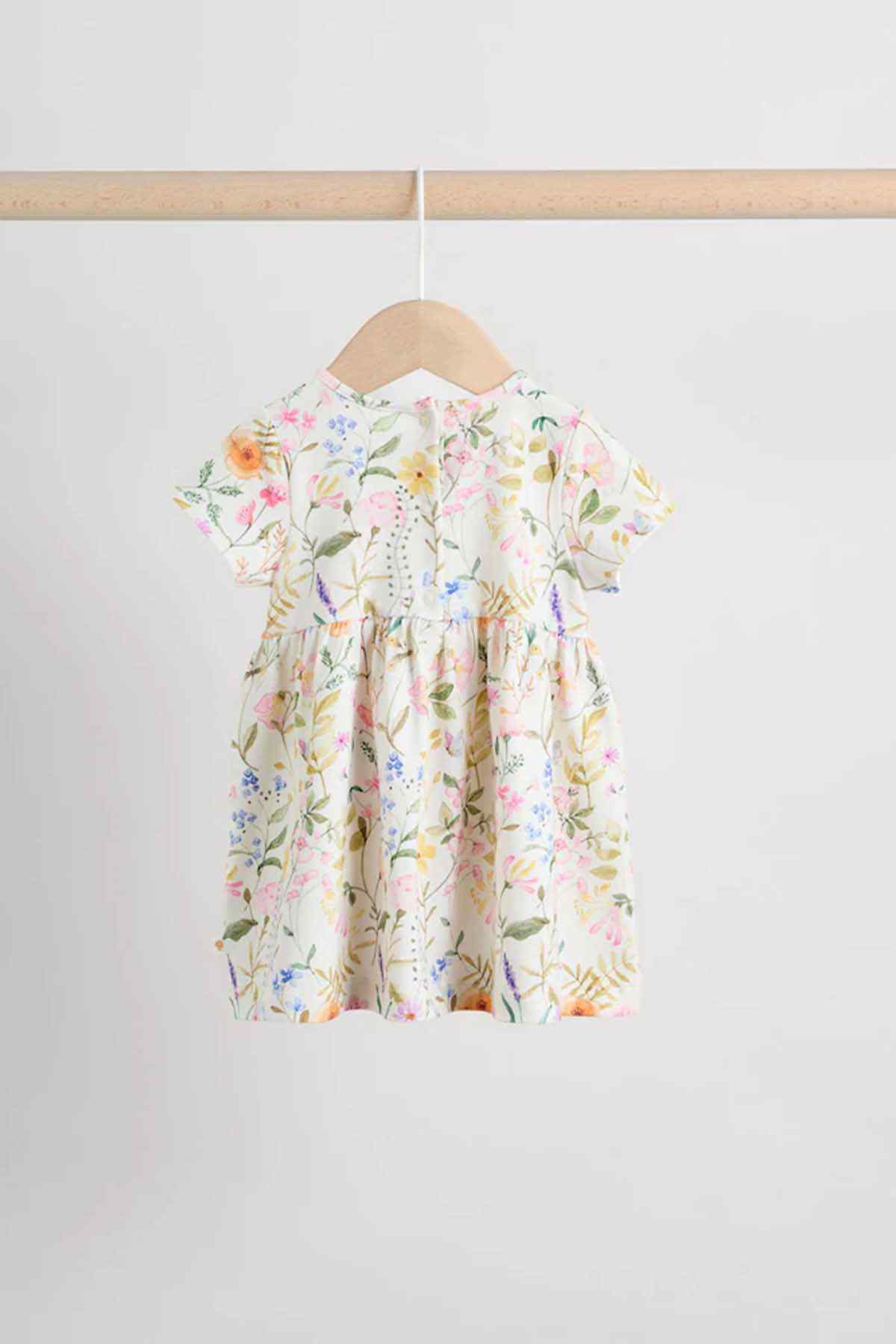 Cream floral kids dress back view with short puff sleeves and gathered waist