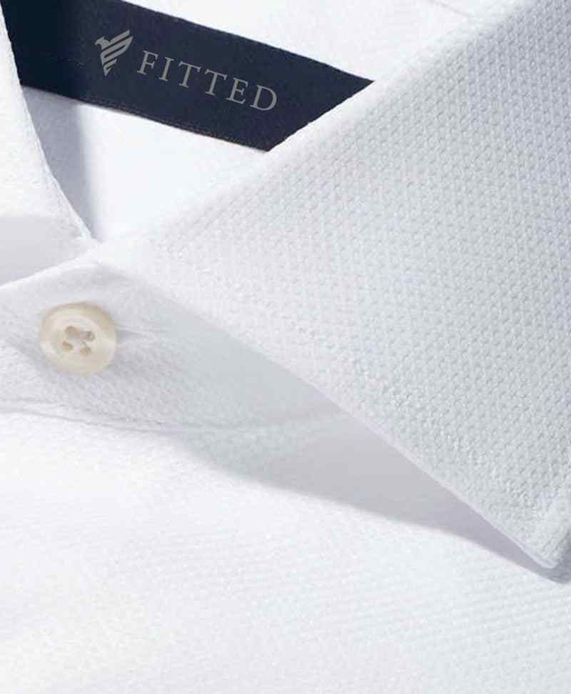 White textured dress shirt close-up with button and collar seam