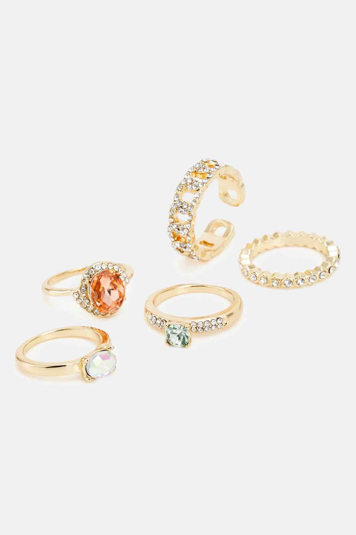 Gold-tone gemstone rings with pastel stones, angled close-up of five styles