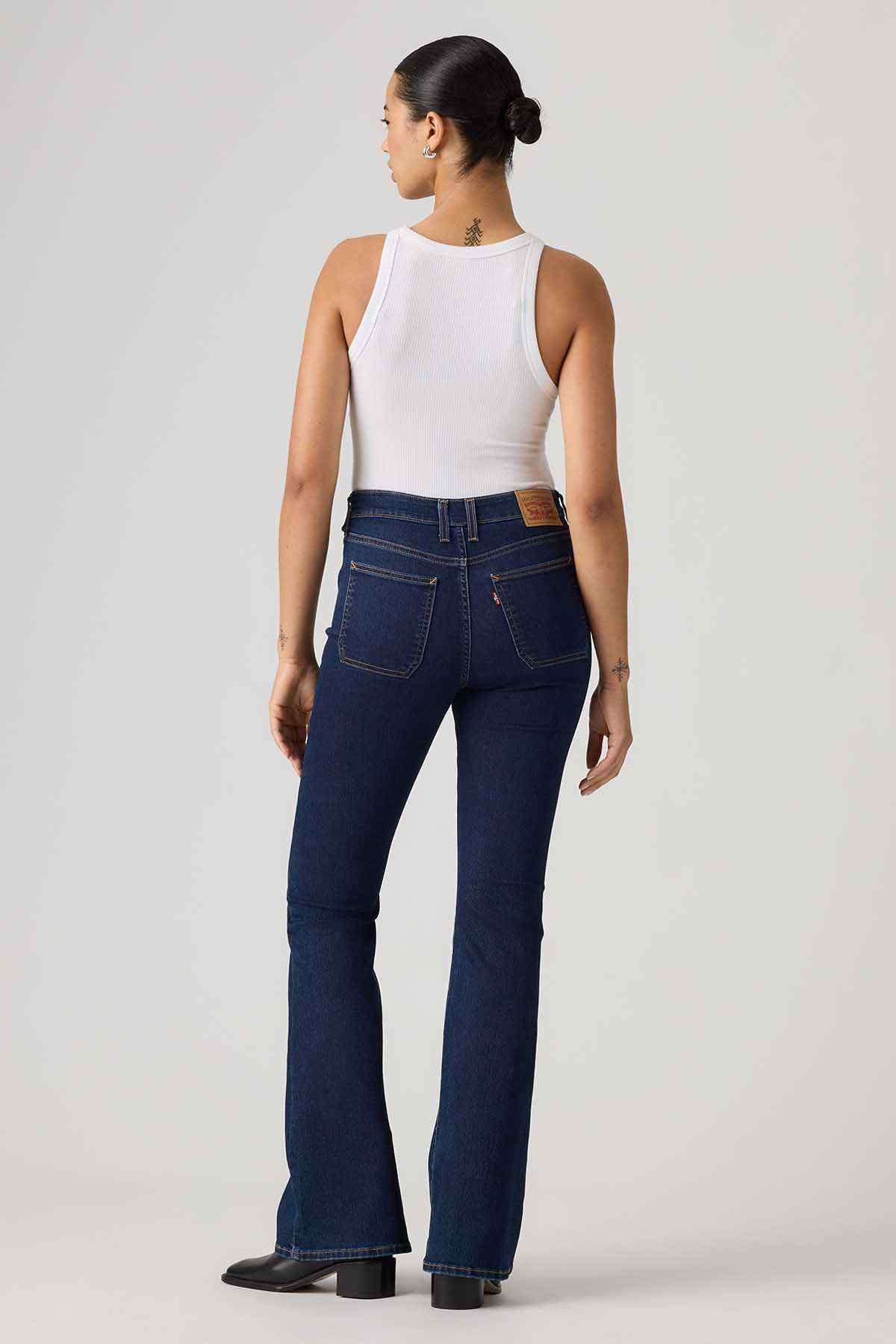 Dark blue denim flared jeans back view with belt loops and patch pockets