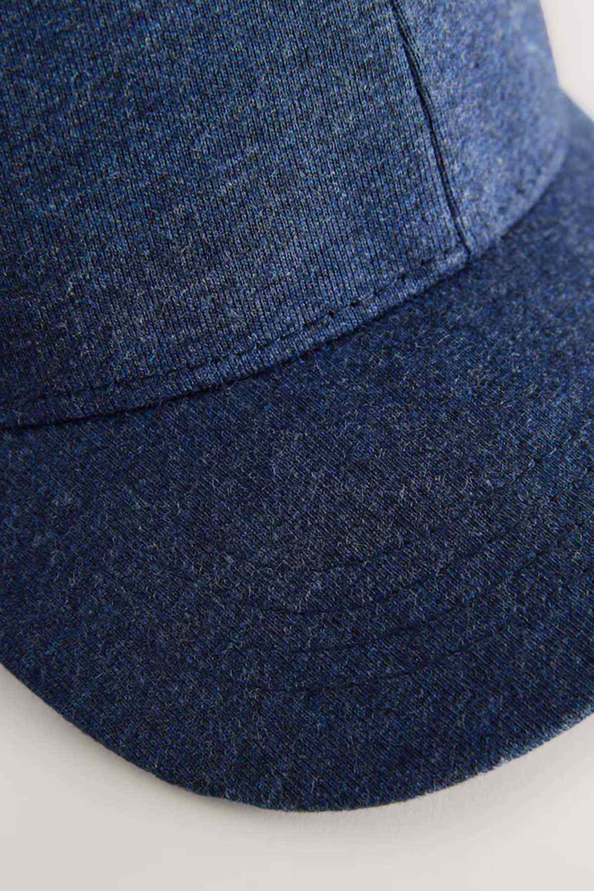 Navy baseball cap close-up of curved brim edge and fabric texture