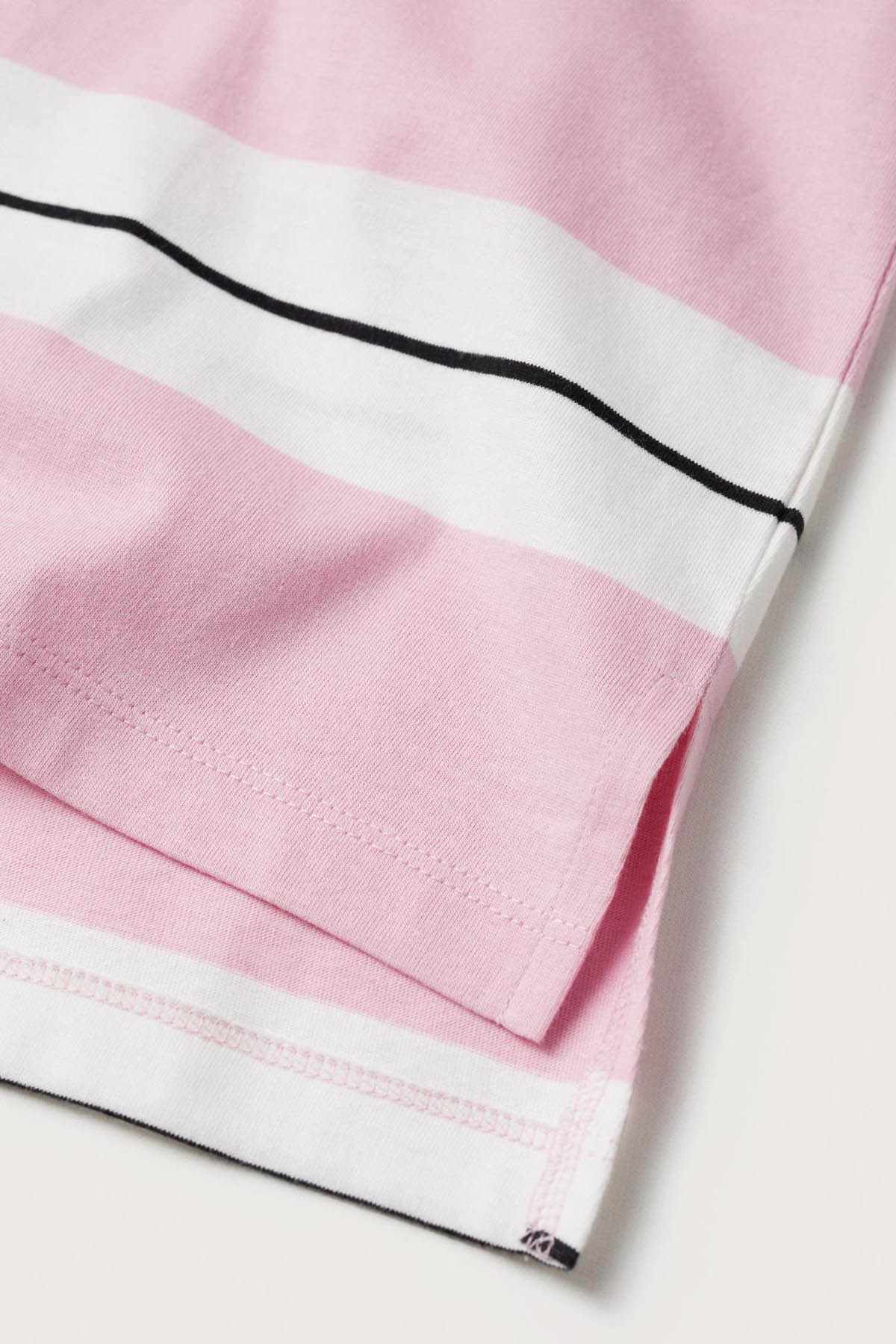 Pink T-shirt hem with stitched detail and black stripe