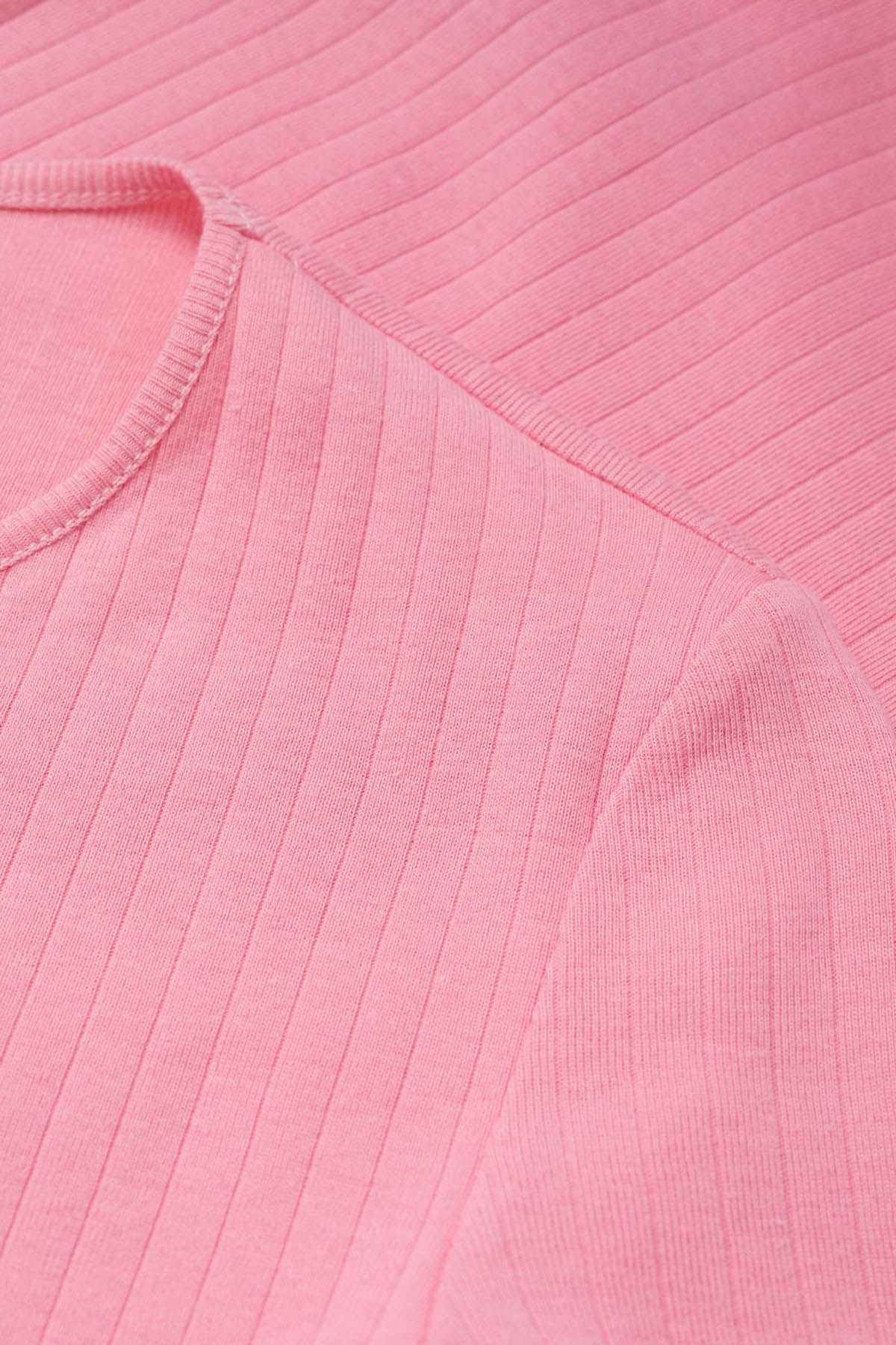 Pink ribbed knit fabric on short-sleeve top, close-up texture