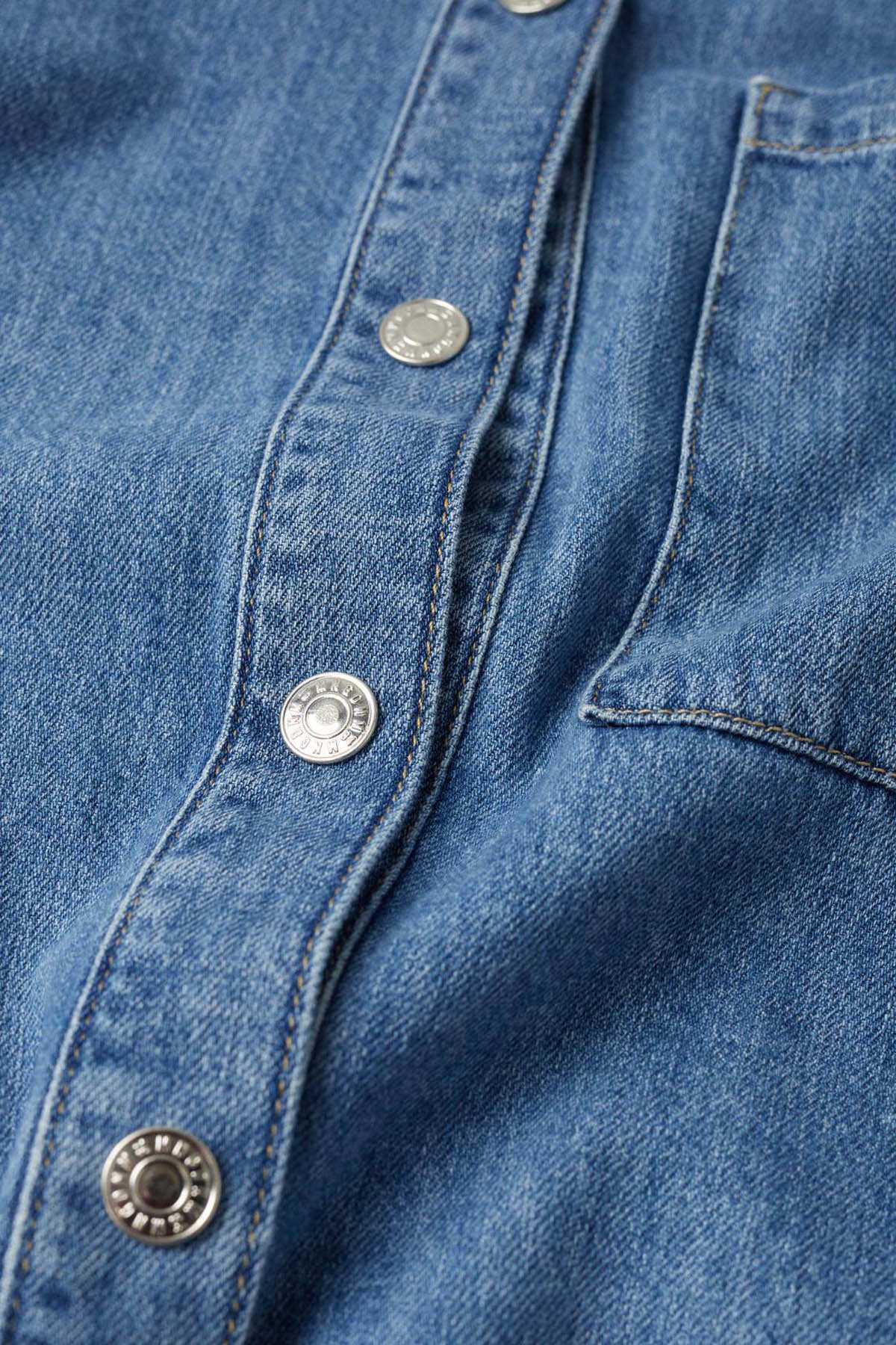 Dark blue denim jacket button placket detail with metal snaps
