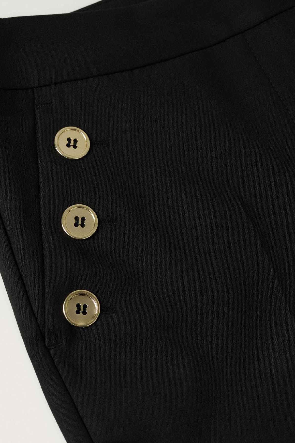 Black jeans with gold button closure detail