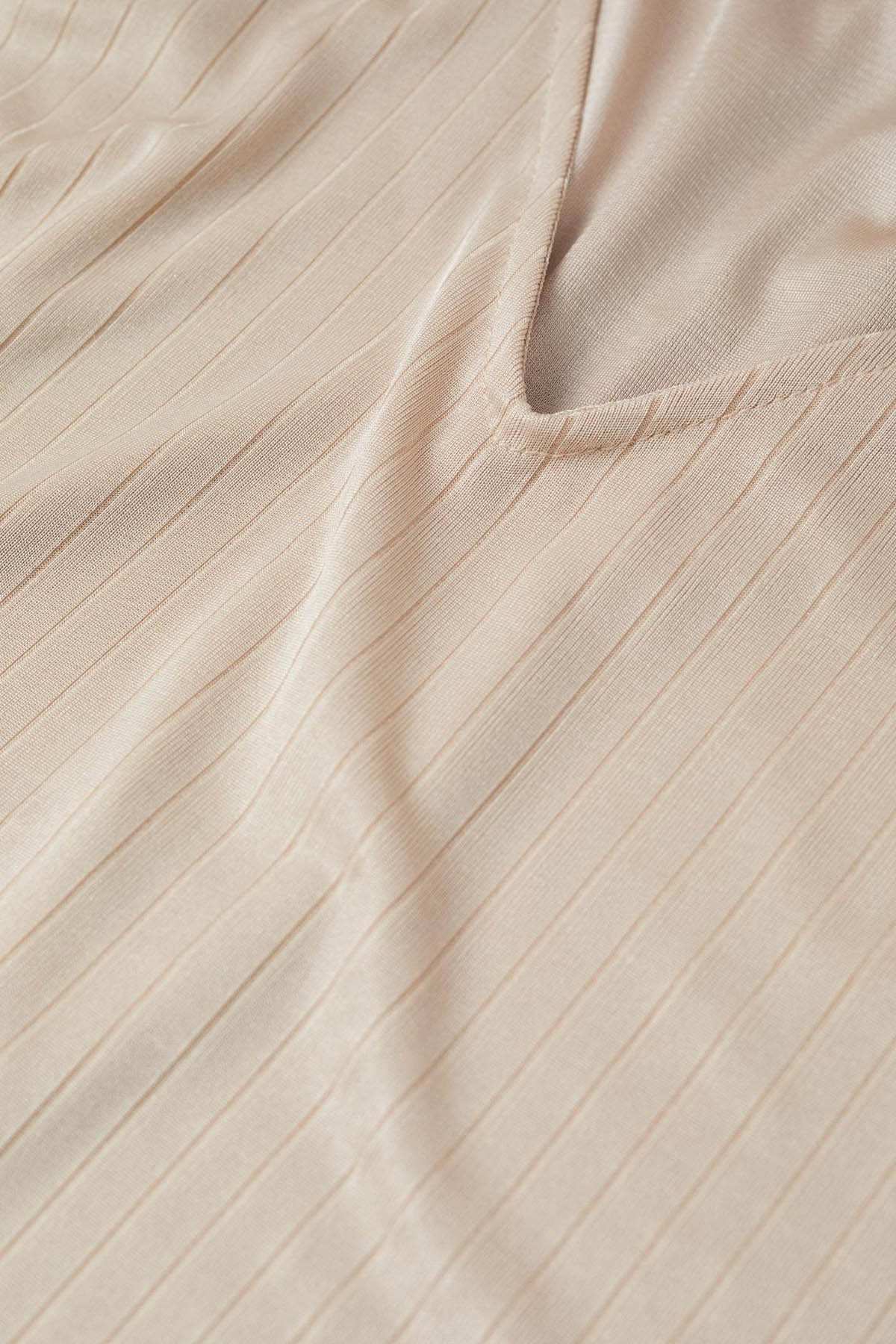 Beige ribbed knit fabric close-up with subtle vertical texture