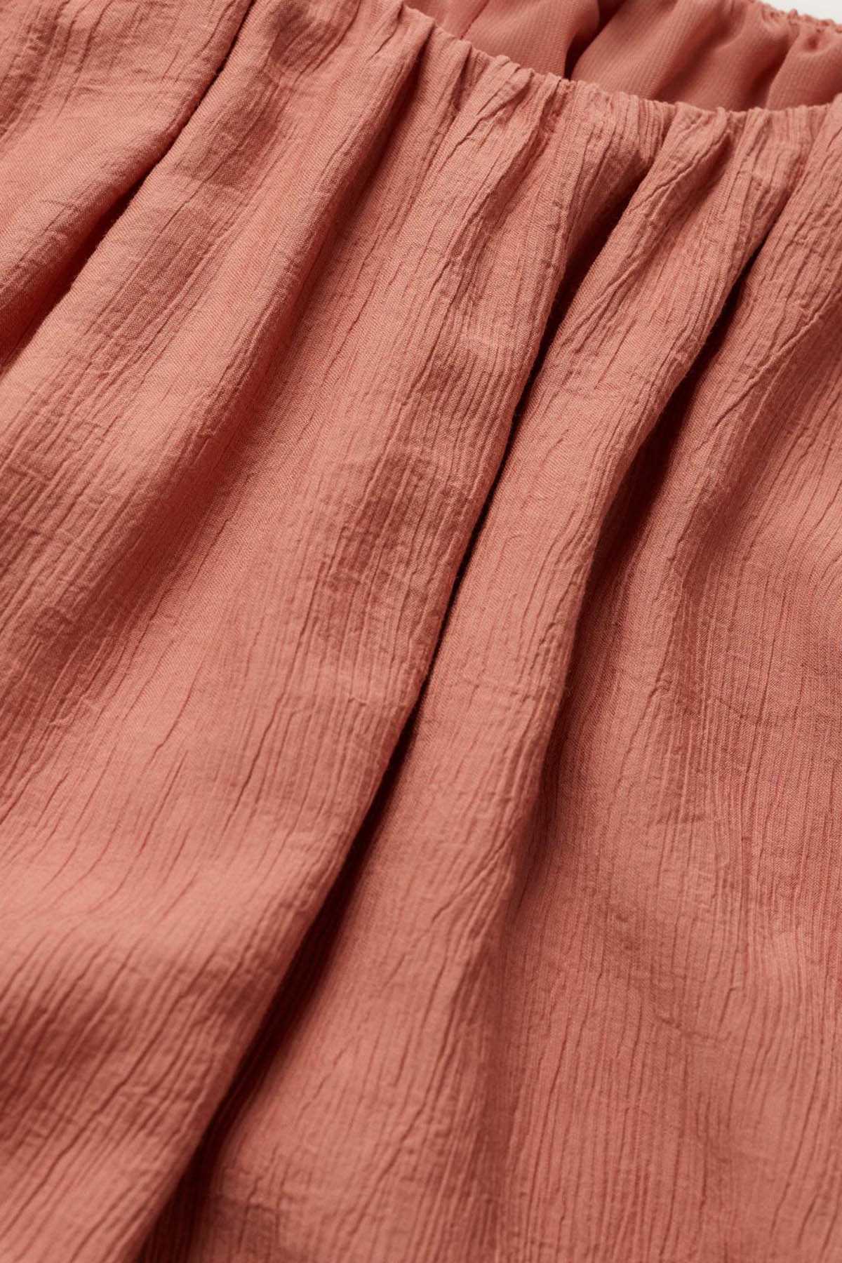 Pink off-shoulder dress bodice with textured weave and gathered seams