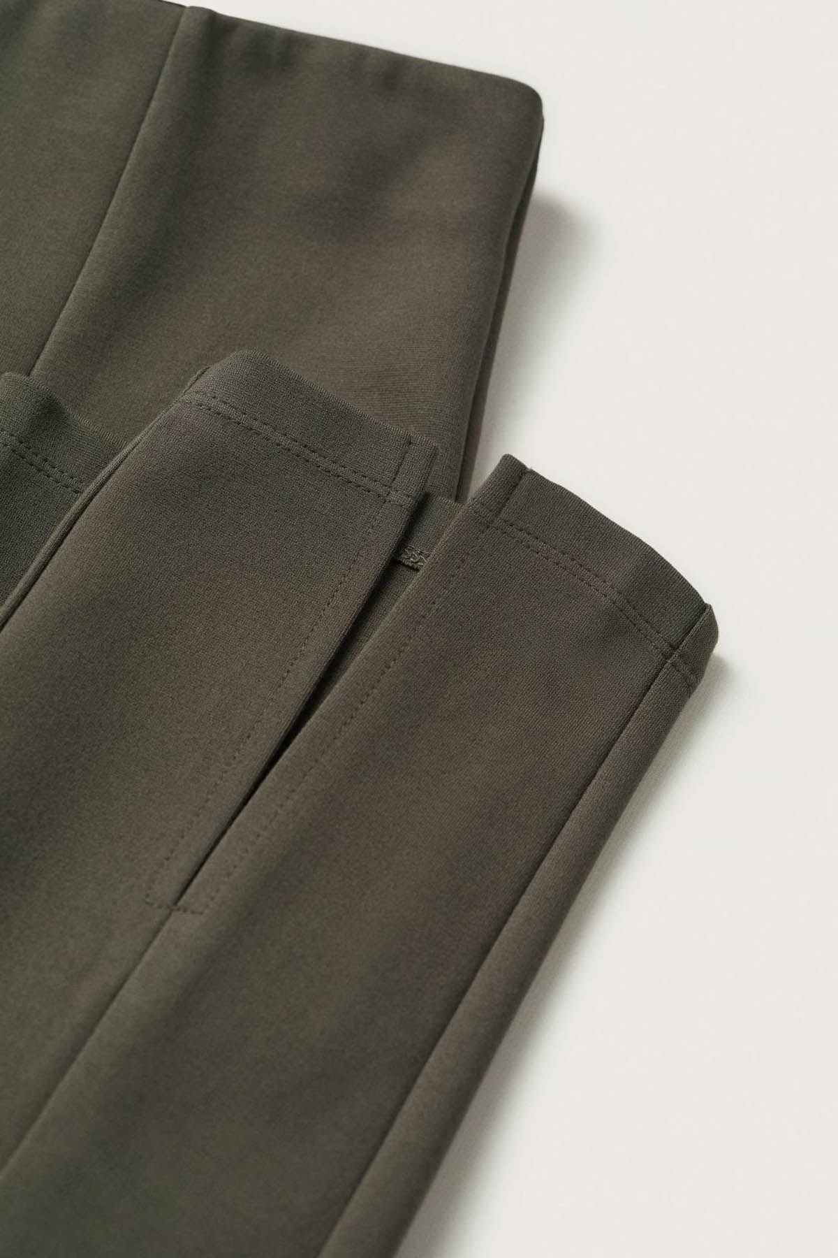 Khaki leggings fabric close-up with stitched seams and hem detail