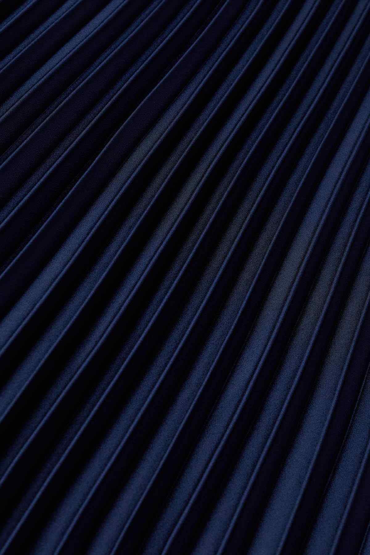 Close-up of navy blue pleated fabric with vertical pinstripes