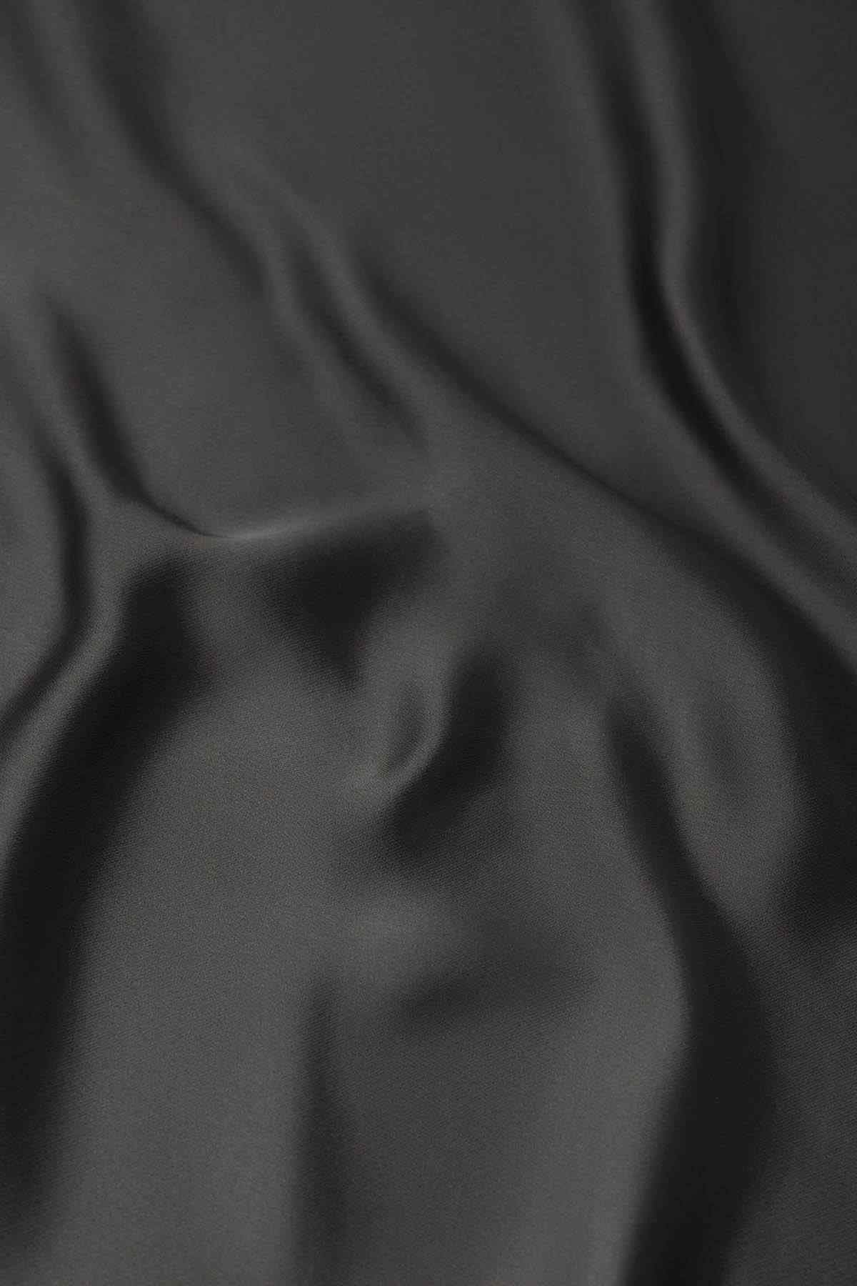 MANGO dark gray satin fabric close-up with smooth drape