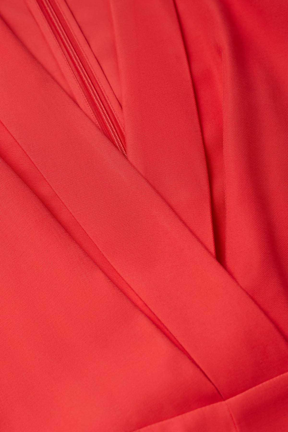 Close-up of coral red wrap bodice stitching and pleats