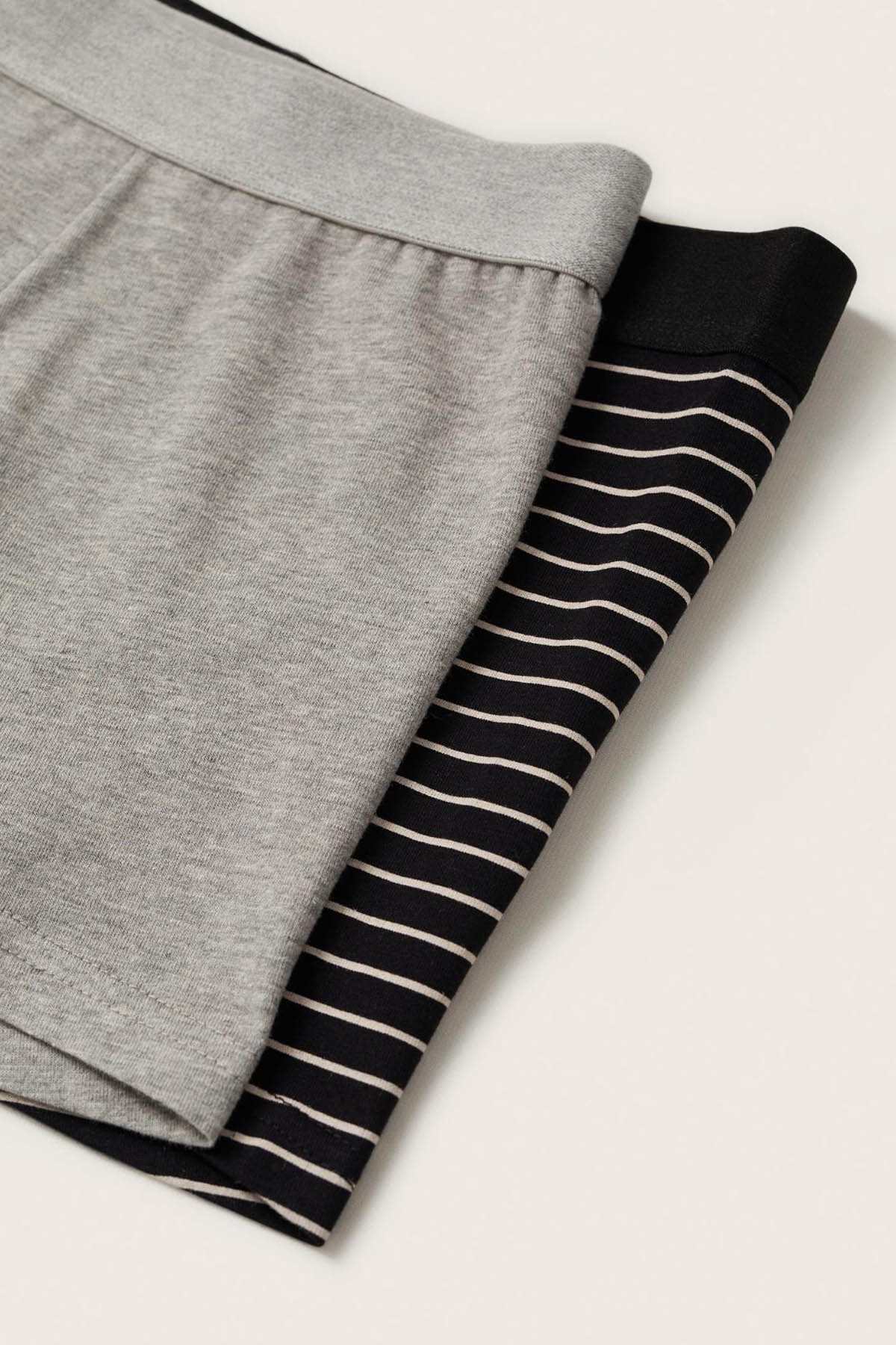Pair of boxer briefs stacked: gray solid and black with white striped waistband