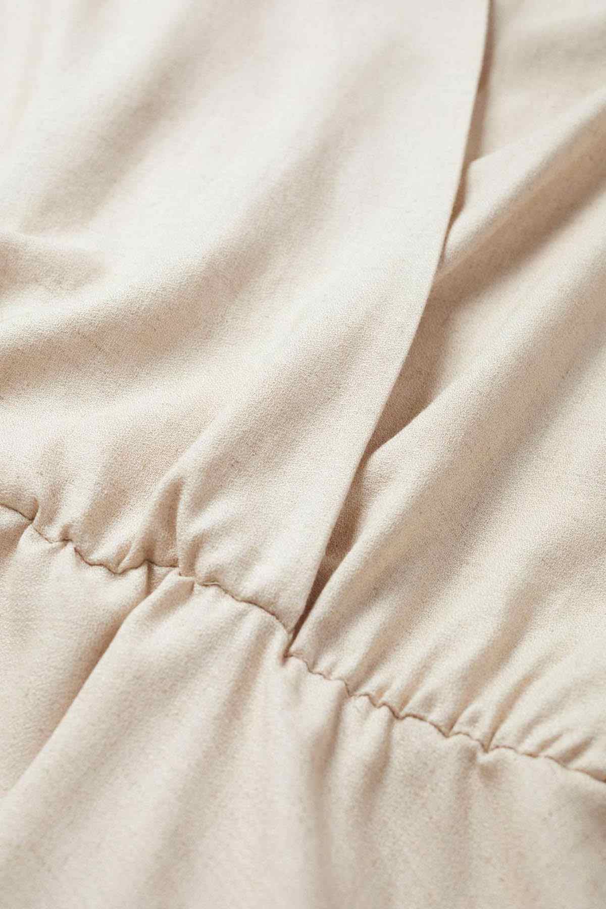 Beige gathered hem and elastic cuff detail on blouse