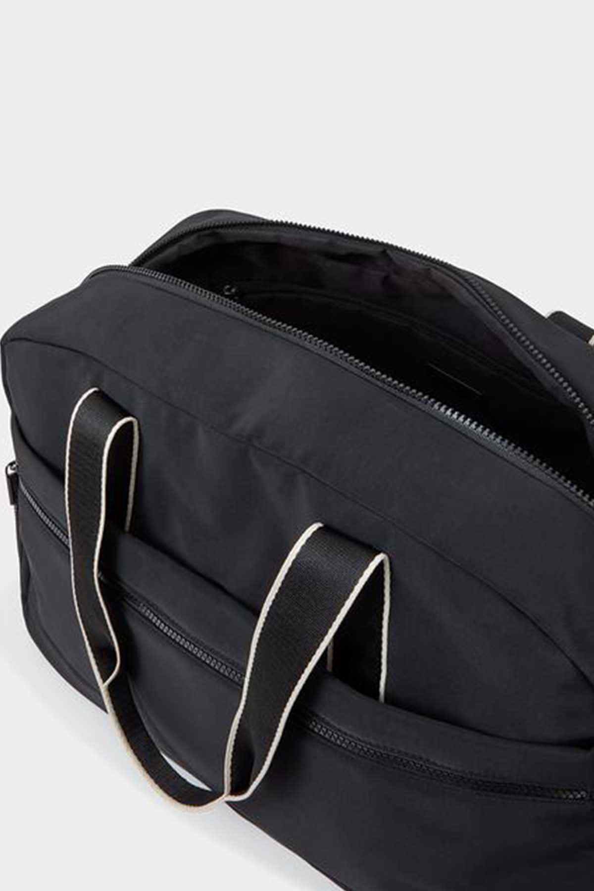 Black duffel bag close-up with zipper opening and striped strap accents