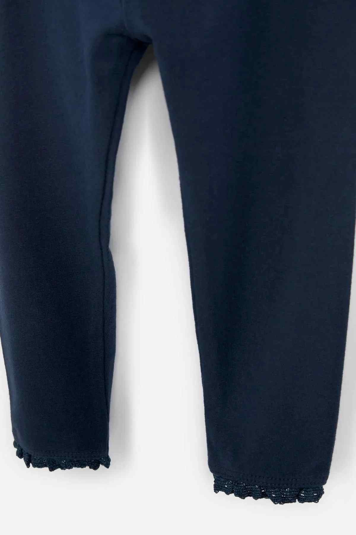 Navy pant legs with frayed cuffs, cropped view