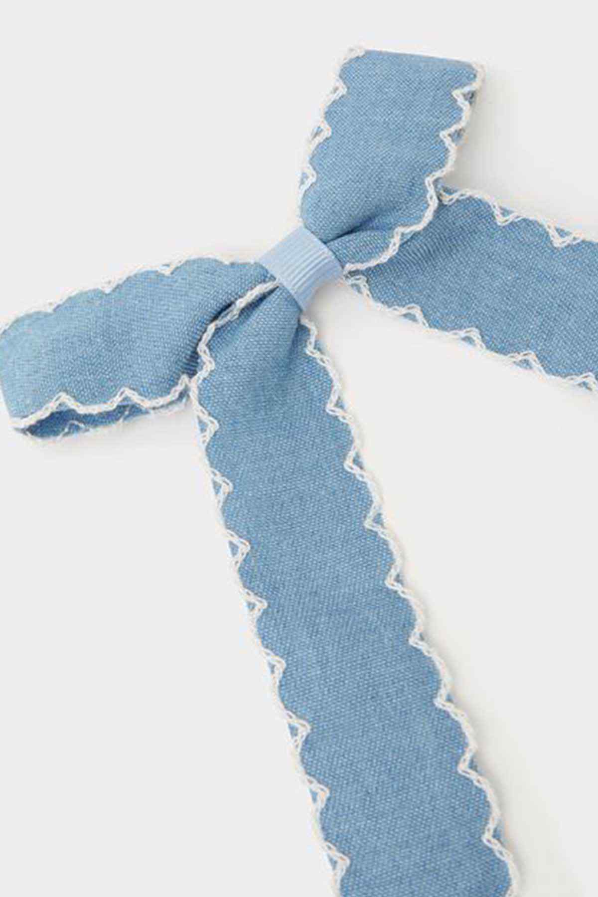 Blue fabric bow ribbon close-up with scalloped trim and embroidered hearts