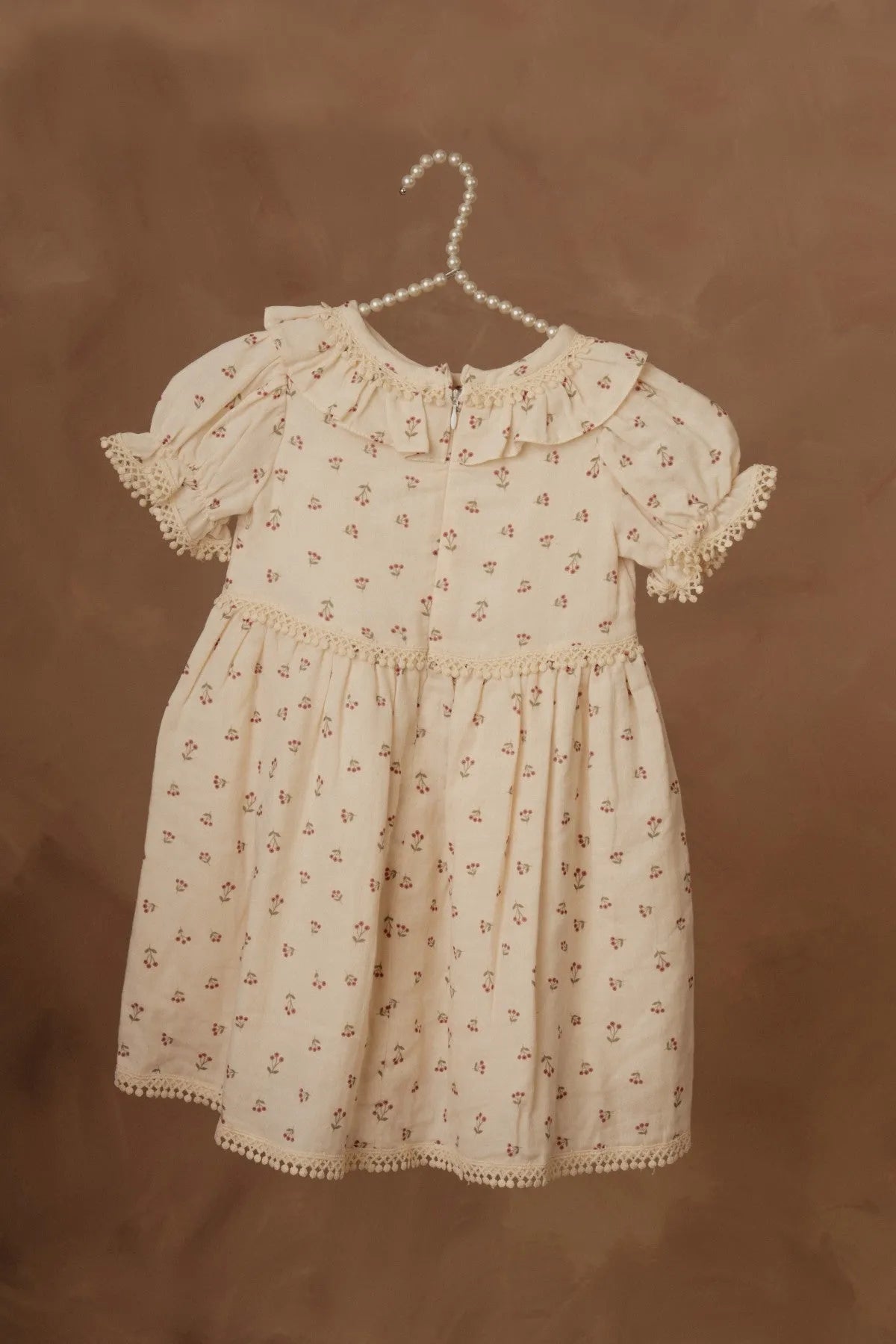 Cream floral short-sleeve dress with puff sleeves, gathered waist, and scalloped hem