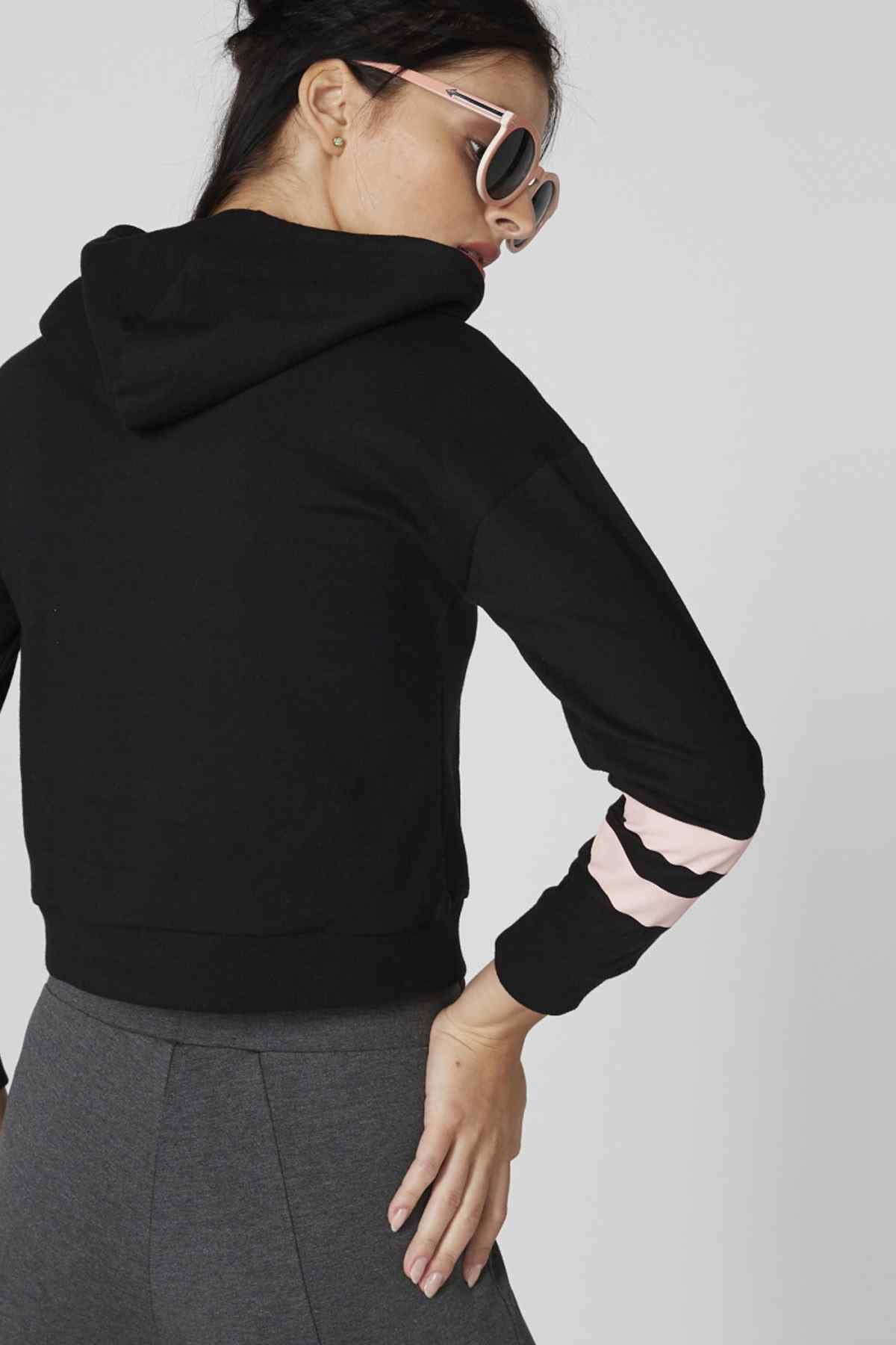 Black cropped hoodie hood, back view with pink stripe cuffs; gray jogger pants