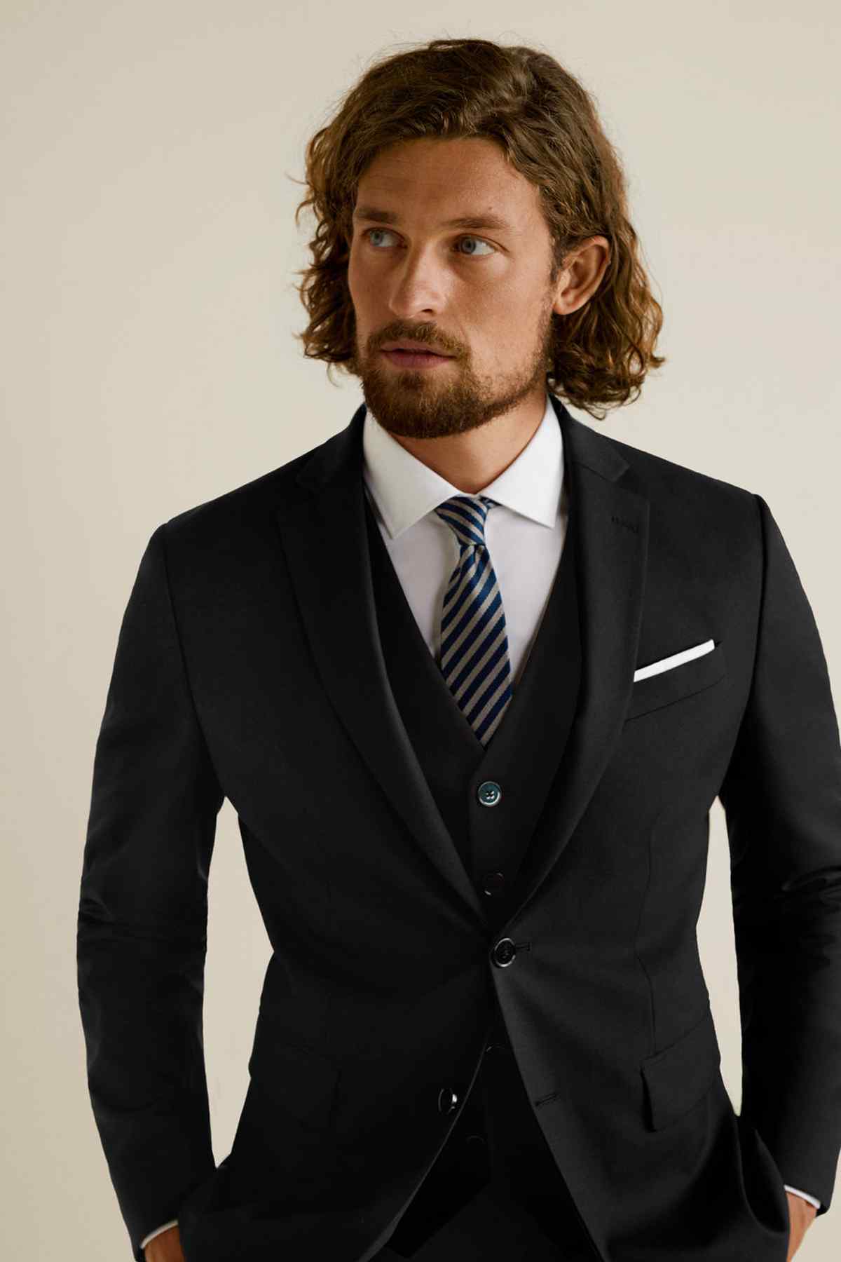 Black men's suit with striped tie and white pocket square