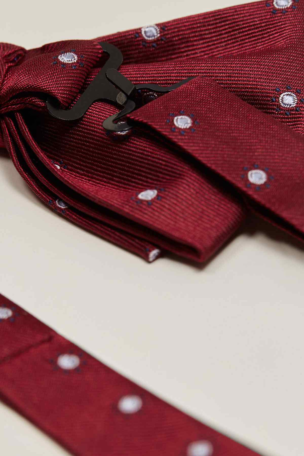 Close-up of red bow tie with dot studs and black adjuster clip